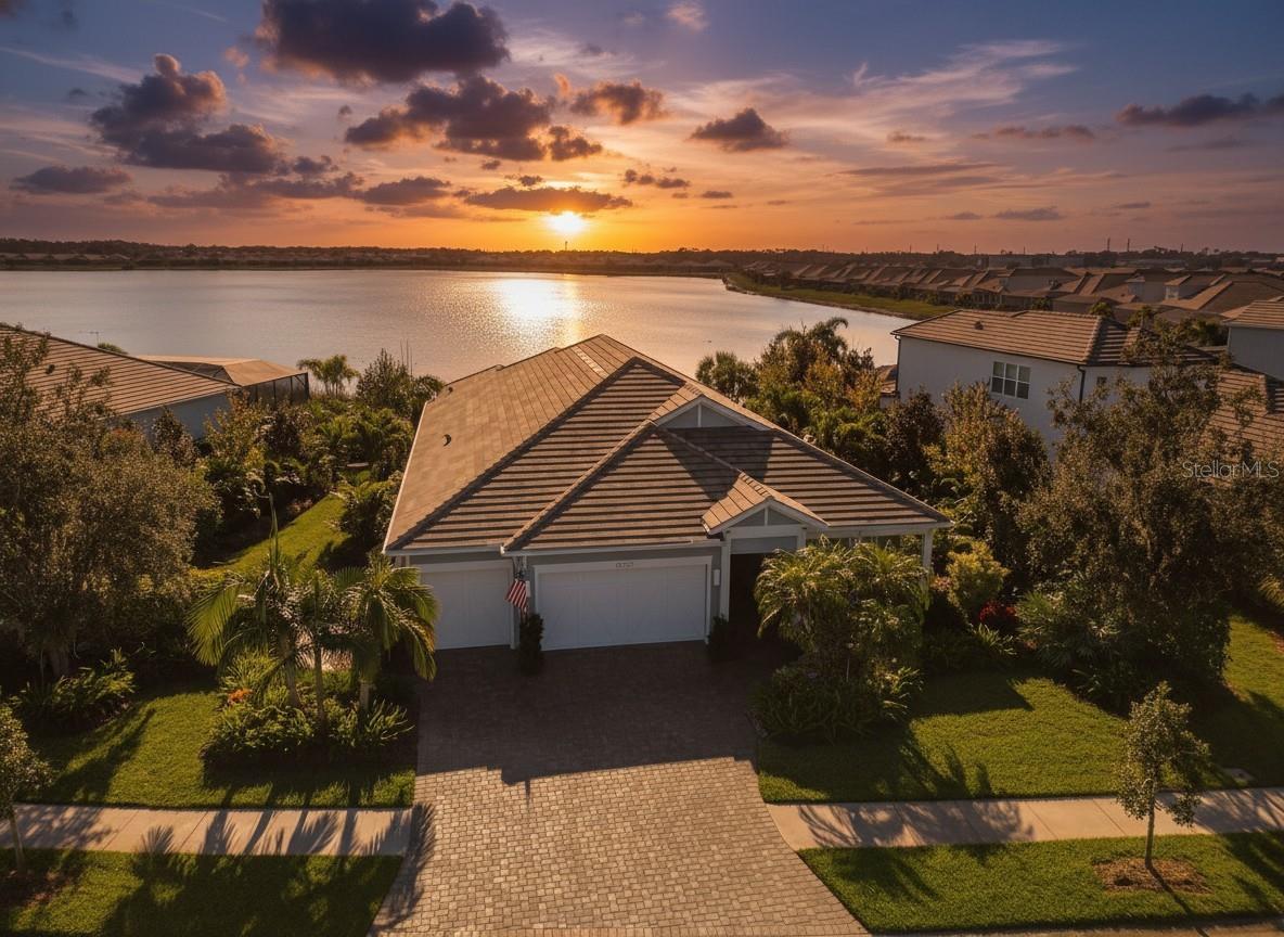Nestled in the heart of the prestigious Lakehouse Cove community, this extraordinary home redefines Florida luxury living with its unparalleled blend of elegance, seclusion, and natural beauty. Sitting on the largest lot in Lakehouse Cove, this property offers an unmatched sense of privacy, with a 35-foot buffer on one side and 50 feet on the other. Adding to its exclusivity, the home boasts 2000 feet of  uninterrupted long lake views, with nothing but serene waters and spectacular sunrises & sunsets as your backdrop—no neighbors in sight.
This North-facing gem is designed to soak in the Florida sunshine, filling every corner with warm, natural light. Inside, the*open Outrigger floor plan is thoughtfully crafted, featuring a split-bedroom layout for ultimate privacy. The expansive chef’s kitchen impresses with two-tone countertops, a gas stove, and abundant storage, making it as functional as it is beautiful. Elegant details like tray ceilings, plantation shutters, and impact-rated windows and sliding doors add sophistication and peace of mind.
Step outside, and you’ll find an entertainer’s dream. The frameless screened patio offers unobstructed views of the shimmering lake, while the heated saltwater pool and summer kitchen set the stage for unforgettable gatherings. The custom landscaped yard and spacious covered patio create a tranquil outdoor haven, and the cozy front patio overlooking a serene wildlife preserve adds even more charm.
Practical upgrades abound here: an extended garage for extra convenience, additional cabinetry for effortless organization, and the removal of interior columns to create an open, airy flow. Every detail has been meticulously designed for comfort, style, and a seamless indoor-outdoor lifestyle.
Purchasing this home with all its premium upgrades and this prime lot directly from the builder would cost over $2.5 million, if available. Why wait or pay more? This stunning, move-in-ready home is a rare opportunity to own the best of Lakehouse Cove today. Furniture included in the sale