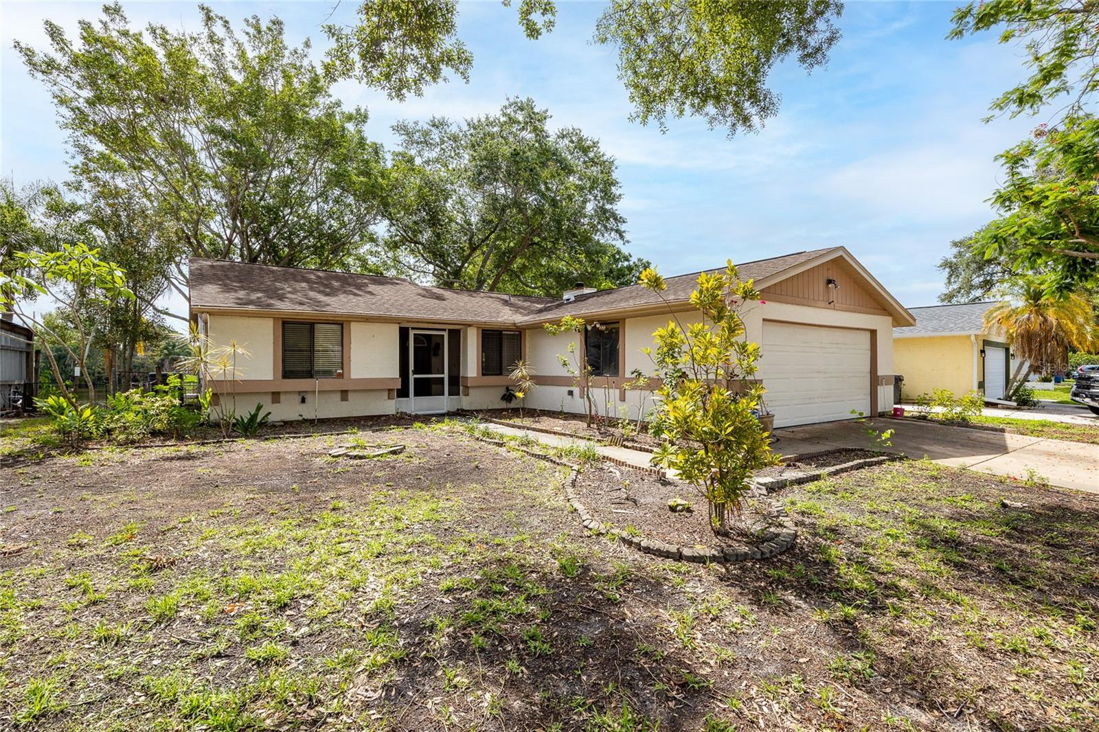 Pond View!!! Charming 3 bed / 2 bath ranch-style home (1,274 sq ft) in a peaceful, family-friendly neighborhood. Built in 1984, this light-filled residence offers a comfortable, single-level floor plan ideal for everyday living and easy entertaining. Enjoy serene pond views from the private backyard — a perfect quiet oasis for morning coffee or safe outdoor play. The home includes a two-car garage, ample parking, and a low-maintenance lot. Well-suited for families, commuters, or anyone seeking a relaxed Tampa Bay suburb lifestyle with quick access to shopping, schools, parks, and major roads. Move-in ready with great bones.  With a little vision this property is a great sweet equity opportunity. Schedule a showing today to experience the setting and location in person.*New Roof Being Installed Next Week