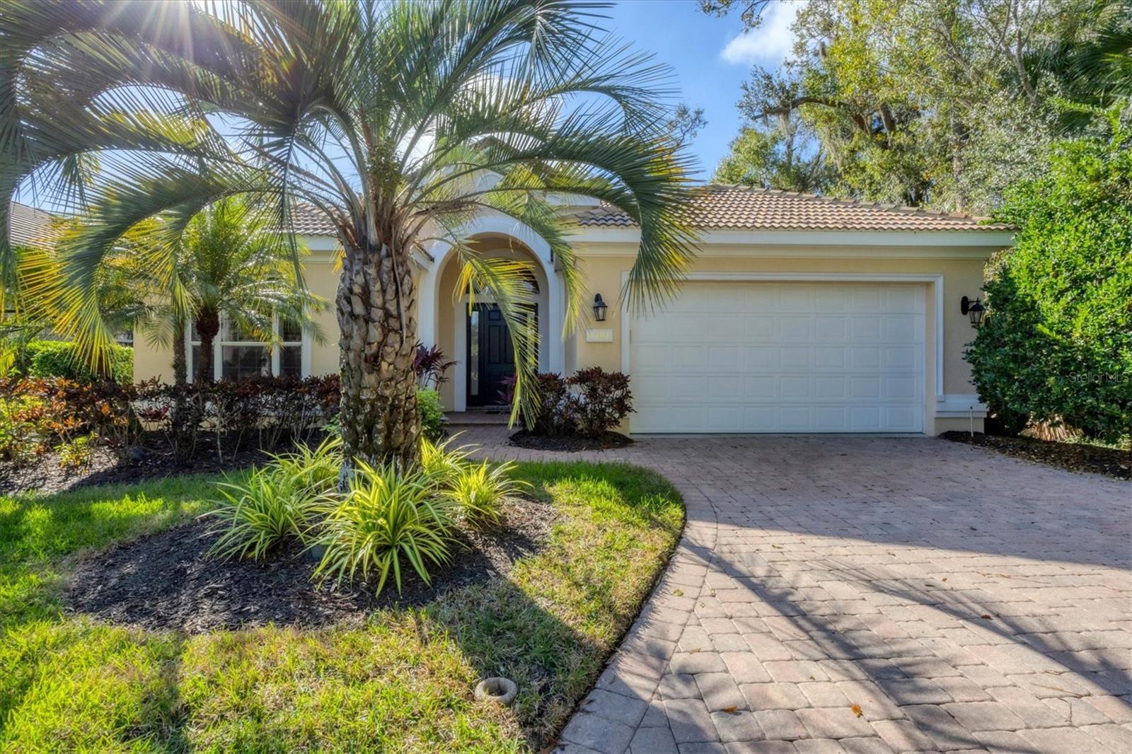 Welcome to this beautifully maintained and updated 3-bedroom, 2.5-bath residence in the desirable Kenwood Park neighborhood, featuring its own community pool. Framed by lush tropical landscaping, a gracious foyer welcomes you into a bright, open-concept home with soaring ceilings, crown molding, neutral paint tones, modern recessed lighting, and ceiling fans throughout. Diagonal tile and hardwood flooring flow seamlessly through most of the home, enhancing the airy feel and private, tranquil views.

The updated eat-in kitchen is both stylish and functional, offering antique white cabinetry—some with glass inserts—sleek quartz countertops, under-cabinet lighting, and stainless steel appliances. A raised breakfast bar, center island with wine refrigerator, built-in desk area, and direct access to the lanai make this kitchen ideal for everyday living and entertaining.

The living room features accent lighting, a modern ceiling fan, and a striking gas fireplace set on a custom accent wall. Triple sliding doors create effortless indoor-outdoor living, opening to a private lanai retreat with an aqua-colored pool, relaxing hot tub with waterfall feature, and convenient half pool bath. The outdoor kitchen, complete with grill, burner, sink, and hood, is perfect for entertaining while enjoying serene tropical views. Tile pavers and an electric roll-down hurricane shutter complete this inviting space.

The spacious primary suite includes hardwood flooring, a seating area, abundant windows, double sliders to the lanai, and two large walk-in closets. The updated ensuite bath is a true retreat, featuring a zero-entry shower, freestanding soaking tub, double vanity with makeup area, granite countertops, modern fixtures, and a private water closet.

Two charming guest bedrooms offer hardwood flooring and ceiling fans, while the shared guest bath features a walk-in shower. The laundry room includes a sink, cabinetry, and a holding shelf for added convenience. The 2-car garage features a separate side golf cart door.
Notable upgrades include a NEW whole-house generator (2025), Bermuda shutters in select rooms, and modern window shades throughout. Move-in ready, this home delivers the very best of Florida living in award winning University Park Country Club. Some furnishings are available for purchase.

University Park Country Club is consistently ranked one of the top courses in Florida featuring 27 holes of championship golf; tennis and pickleball; fitness center, croquet – as well as an array of social and group activities.  Just a 15-minute drive outside this peaceful enclave is downtown Sarasota, with shopping, arts & theatres, museums, dining and entertainment, top-ranked healthcare, beaches and SRQ International Airport.  Two miles east of UPCC is the convenience of I-75, University Town Center with 300 nationally known and homegrown shops, restaurants, fitness studios, services and attractions, the Nate Benderson Park, home of world-class rowing events and the Mote Marine Aquarium.

Enjoy the club amenities with the required minimum of a Social membership at UPCC, which is owned by the residents through a Recreation District.
Dining room chandelier does not convey.