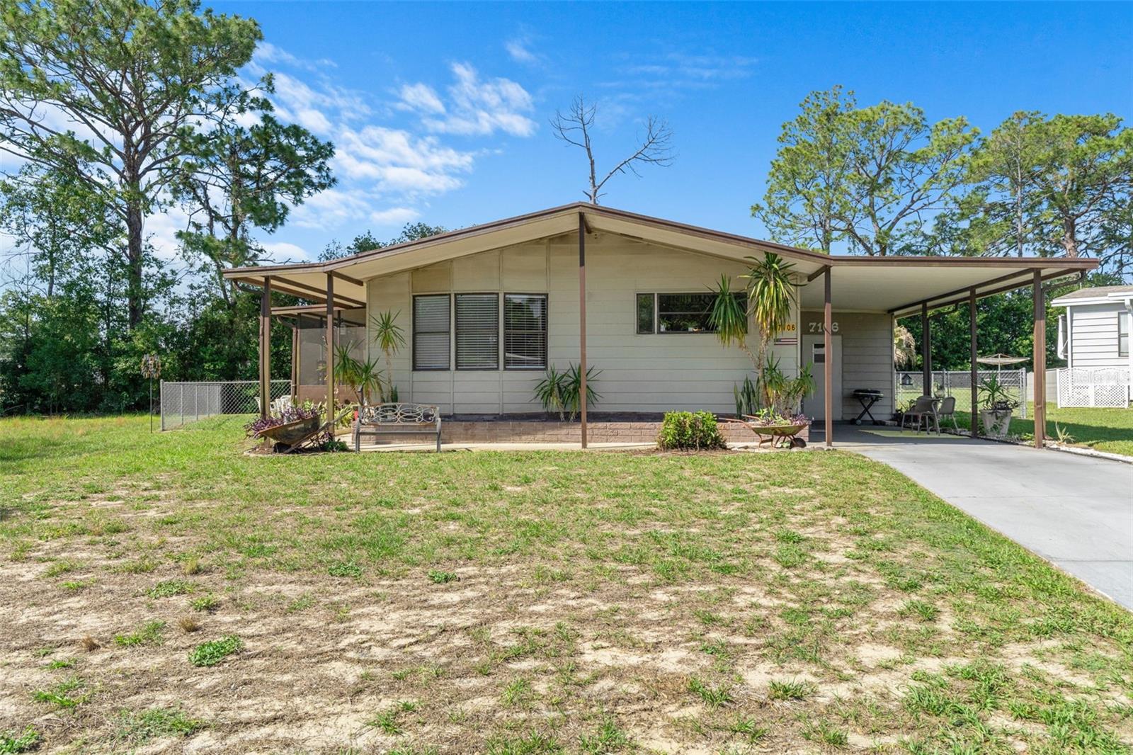 Welcome home to this adorable and move-in ready 1986 doublewide manufactured home featuring an oversized fenced backyard and a bright open-concept layout connecting the living room, dining area, and kitchen. The spacious primary bedroom includes a private en suite bath, creating a comfortable retreat at the end of the day. 
Major updates have already been completed for peace of mind, including a new chain-link fence, new hurricane straps and new shingle roof  in 2020, in 2021 new heat pump, in 2023 new ductwork.  In 2024 the porch was re-screened and a new door was added for easy backyard access. In 2025 new lighting and ceiling fans were installed. 2026 improvements include commercial-grade luxury vinyl plank flooring and updated smoke detectors.  There is flooring available to complete the guest bedroom if so desired. The laundry and workshop are located in the utility room off the carport.
This home has been lovingly maintained, and is ready for its new owners to move right in. Some furniture is negotiable, making this an even easier transition. Don’t miss this cute and updated home with plenty of outdoor space to enjoy!