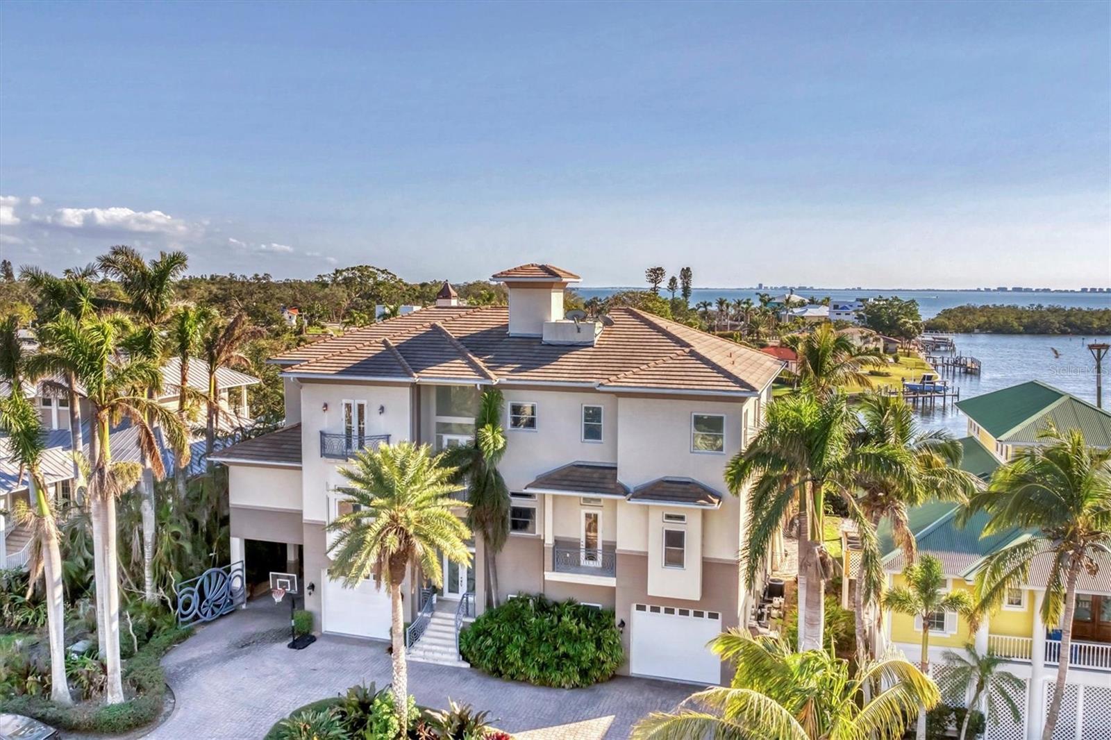 Nestled behind the gates of Hawks Harbor, this unparalleled waterfront estate embodies the epitome of luxury living, offering commanding, panoramic views of the sparkling bay from nearly every room. Masterfully designed to provide both comfort and elegance, this residence seamlessly integrates opulence with the natural beauty of its stunning waterfront setting.
As you step inside, the grandiose 12-foot ceilings and meticulously laid travertine marble floors set the stage for an extraordinary living experience. Every corner is a testament to craftsmanship, with sweeping bay views flooding the open spaces. The expansive family and great room are anchored by a decorative gas fireplace, offering warmth and charm, while disappearing glass sliders open to an expansive covered balcony—creating a seamless connection to the outdoors.
The recently redesigned chef's kitchen is a masterpiece, featuring an oversized quartz island with a sleek stainless-steel prep sink, a state-of-the-art Wolf double oven, a five-burner DCS gas cooktop with griddle, and a Sub-Zero refrigerator/freezer. Floor-to-ceiling windows frame a spectacular, ever-changing backdrop of tranquil bay waters.
For those who love to entertain, this home excels. An opulent eight-seat theater room with a marble bar, a custom-designed game room complete with a bar and a second-floor wet bar with both refrigerator and dishwasher, giving endless opportunities for indulgence and enjoyment.
The master suite is nothing short of extraordinary—a serene private sanctuary with full bay views, a lavish dressing room with custom-built storage and a granite-topped island, and a spa-inspired bath with a steam shower, rain shower, elevated garden soaking tub, and dual vanities. The wrap around balcony on the third floor and rooftop crow’s nest balcony give an ideal vantage point for savoring dramatic sunrises and sunsets over Longboat Key.
The outdoor living spaces are nothing less than spectacular. Designed by Lucas Lagoons and featured on Animal Planet’s Insane Pools, the two-story pool features a stunning mosaic stone waterfall that cascades into an infinity-edge pool. A summer kitchen, and custom outdoor shower elevate this space into a true resort-like oasis.
For the boating enthusiast, this estate is unparalleled, offering two private docks, including a 15,000 lb. lift and a secondary dock equipped with a kayak and Jet Ski lift on a moveable track—ideal for all of your aquatic adventures.
Additional exceptional features include hurricane-rated windows, a four-stop elevator, an invisible dog fence, a tankless hot water system, a central vacuum, water softener, and a golf cart garage. Just minutes from Sarasota Bay’s open waters, this extraordinary home offers the perfect combination of privacy, exclusivity, and ultimate waterfront living at its finest.
This estate redefines the standard for opulence, comfort, and sophistication—creating an experience that is truly second to none.