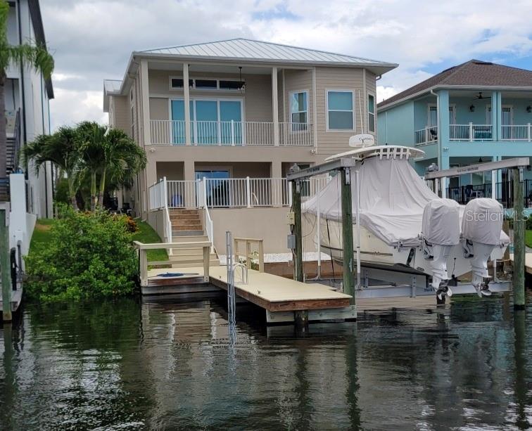 One of the highest lots in the Gulf Harbors communities that features all of the finished space upper and lower above base flood elevation. This house was built in 2022 to withstand storms and has two electrical panels that can be fed by emergency generators if city power is shut off. 
Open floorplan with views of the canal from the primary suite, balcony, living room and kitchen. The study next to the dining area could be used as a formal dining room. The primary suite and great room have 12 ft ceilings.
Features include; elevator, impact windows and doors, metal roof, crown molding, 3,749 finished sq ft above base flood elevation, 2501 second floor and 1248 first floor, and 1210 of garage space that is 51 ft long to hold a bunch of toys.  
The finished lower level offers privacy for multi-generational living or overnight visitors including a bedroom with en suite bathroom and walk in closet, living room, kitchen and office that has washer and dryer hookups or could be made into a 5th bedroom. The lower level also walks out to the pool and dock with 13k boat lift.  
Enjoy the sunset view from the balcony or pool down the long canal with no rear neighbors in this ideally located home. You can take a short golf cart ride to the private beach or to downtown New Port Richey for dining or entertainment or take the boat out to the many beautiful islands or offshore for a day of fishing or diving from this like new luxury waterfront home in Gulf Harbors Sea Forest. 
This home is move in ready for you to start living the saltwater lifestyle today.