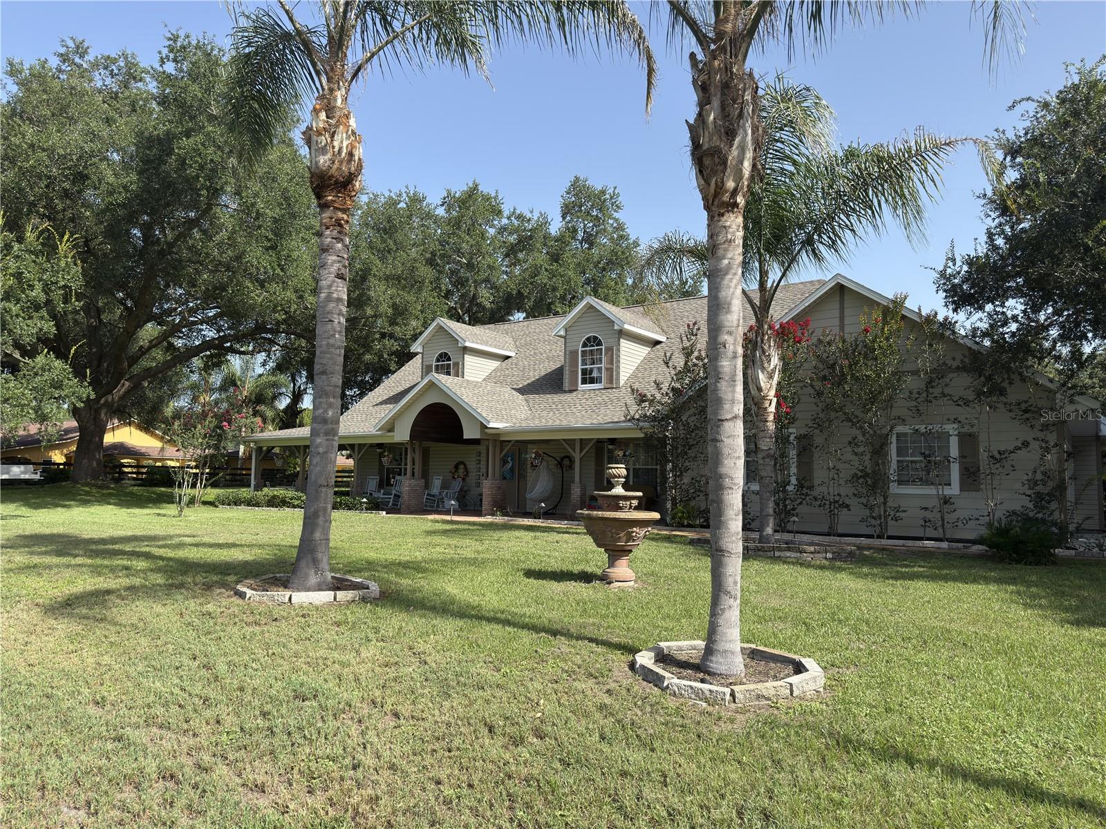 WOW! An amazing equestrian farmhouse with tons of space AND an opportunity to generate income, create rental space, or run your own business, all in the same property? Along with a no-hassle HOA? Absolutely!  Bring your horses and escape to your own private estate on nearly 2.5 beautifully fenced acres — where luxury, space, and flexibility come together just minutes from all the amenities of downtown Mount Dora. Immaculately maintained, this home boasts a NEW roof (2025), NEW water heater, and NEW driveway and garage pads.

What truly sets this property apart is the incredible 50’ x 52’ barn/garage with RV-height clearance — an exceptionally rare feature with endless possibilities. This structure is plumbed for adding a restroom or kitchen, and even has its own separate septic tank.  Perfect for horse enthusiasts, car collectors, RV owners, hobbyists, contractors, or business owners, this versatile space has even served as an income-producing workshop in the past.  The covered front porch of the structure can be used as a parking pad for a possible in-law suite, or easily converted to horse stalls while preserving the interior space for storage or a tack room. A climate-controlled 12’ x 36’ office is attached, making it easy to run a business or work from home without sacrificing living space.

This stunning 4-bedroom home was designed for both everyday comfort and unforgettable entertaining. From the moment you step inside, you’re greeted by soaring cathedral ceilings, rich real wood flooring, and an open, inviting layout filled with natural light. Upstairs, a spacious loft with two separate sitting areas creates the perfect space for a media room, game room, home library, or additional lounge areas. Privacy and convenience abound, with three of the four bedrooms featuring their own en-suite bathrooms — ideal for guests or multi-generational living. The spacious first-floor office can also function as a fifth bedroom.

Start your mornings on the charming covered front porch, where you can unwind and take in the peaceful surroundings of this quiet, upscale neighborhood. Step outside and discover your personal Florida oasis. The expansive screened lanai features a heated pool and spa, surround sound system, outdoor TV viewing, and built-in cooling misters — creating the ultimate year-round entertainment space for hosting family and friends in.

The fully board-fenced property offers room for horses, recreational vehicles, and all your outdoor toys. The $75-a-year HOA fee is voluntary and used to decorate the entrance for the holidays.  Even with the peaceful country setting, you’re only five minutes from the restaurants, shopping, festivals, and waterfront charm of downtown Mount Dora. The property has been meticulously maintained inside and out; the seller, who is a licensed contractor, recently had a home inspection completed and addressed every issue. This one-of-a-kind estate offers the rare combination of luxury living, functional workspace, income potential, and room to breathe. Opportunities like this are exceptionally rare — schedule your private showing today and experience everything this extraordinary property has to offer.