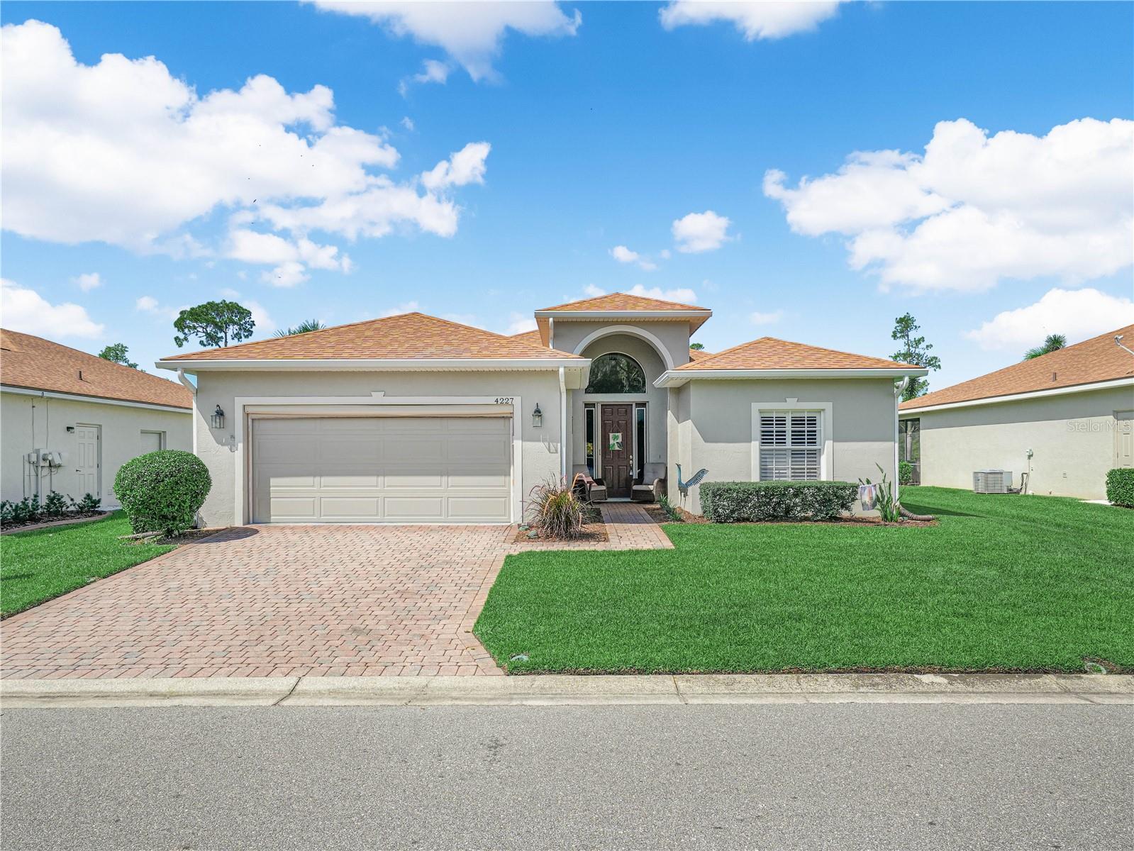 Welcome Home! Beautiful Views from the front and back of this home. 4227 Berwick Drive Lake Wales, Florida 33859 is ready for a NEW OWNER. This 3 Bedroom / 2 Bath BISCAYNE floor plan home is located in Lake Ashton, a guarded and gated Florida 55 Plus community with Resort Style Amenities and Activities. With 1,847 sq. ft. living area plus a Florida Room with Acrylic windows, this home is centrally located to amenities available to residents in Lake Ashton. Upon arrival, you'll appreciate the quality landscaping and paver driveway. Approaching the covered front entry, the front door with matching sidelights greets you. The arched window above enhances the entry and provides great natural light to the welcoming foyer with high ceiling. Just off the foyer is a pocket door that can be closed to provide privacy to the 2nd and 3rd bedrooms and guest bath. The 2nd bedroom is on the front of the home and has a bay window, ceiling fan and built in closet. The adjacent guest bath has a shower/tub combo and comfort height vanity. The 3rd bedroom offers a ceiling fan, 2 built in closets and could be used as a flex room.  The large combination living & dining rooms are located directly in front of the foyer. The formal dining area is great flex space and can accommodate gatherings with friends and family. The large living room with vinyl flooring that resembles wood has a decorative ceiling fan and a triple slider that leads to the tiled lanai which overlooks the East golf course, 15th Tee Box.  The large primary bedroom overlooks the golf course and double doors provide privacy to the bedroom from the primary bath. Inside the primary bath are 2 walk-in closets, a large corner soaking tub, 2 comfort height vanities, and a separate shower area with a walk in shower and glass enclosure, toilet and linen closet. The kitchen features Quartz counters, SS Appliances, Quartz backsplash,  and the under cabinet lighting is a bonus. Next to the kitchen is the dinette area with a large window and a double slider that also opens to the covered and enclosed lanai with tile flooring.  Between the garage and kitchen is the laundry room with cabinetry for additional storage. The washer and dryer will convey with the sale. The Primary bedroom, Florida Room and Dinette all have a fantastic view of the golf course. You'll enjoy watching the golfers and natural wildlife. From the front of the home, you'll enjoy the pond and nature views, too. Make sure you always have a pair of binoculars on hand!  Improvements to this home include: New Sod, SS Appliances, Plantation Shutters in the Dinette, Primary Suite, Bed 2 & Bed 3. Upgraded Lighting Fixtures and Ceiling Fans, Rolldown Shades in the Florida Room, and Awnings on the Exterior Florida Room windows and Primary Suite.  The ROOF was replaced in 2021. Water Heater was replaced in 2022.  There is an automatic screen on the garage door, too.  Lake Ashton is a Florida 55 Plus community. Residents enjoy a main clubhouse with bowling lanes, movie theater, restaurant, card, craft and billiard rooms, fitness center, outdoor temperature controlled pool, bocce courts, tennis courts, shuffleboard courts, grand ballroom and MORE. The Health and Fitness Center offers a large indoor temperature controlled pool, 2 outdoor hot tubs, fitness center, pickle ball courts, tennis courts, card, craft and billiard rooms, large multi-purpose room, 1/2 court indoor basketball, indoor racquetball, sauna and MORE. Make an appointment today.