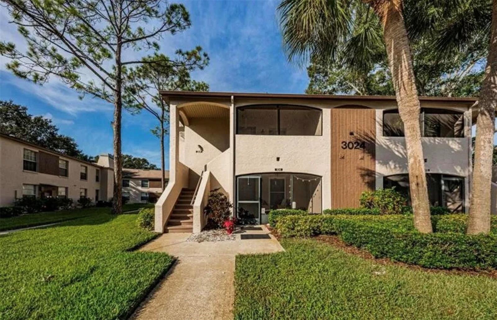 TURNKEY and move-in ready! Welcome to Bonaventure, a pet-friendly community in the heart of Palm Harbor. This beautifully updated 2-bedroom, 2-bathroom second-floor condo includes a desirable split-bedroom floor plan, approximately 900 square feet of living space, and a convenient parking space located directly in front of the building.

The updated kitchen features elegant quartz countertops, newer appliances, and ample cabinet space. Throughout the home you'll find luxury vinyl plank flooring in the main living areas, tile flooring in the kitchen and bathrooms, and a stunning stacked stone fireplace feature wall that creates a warm and inviting focal point. The spacious primary suite includes a large walk-in closet, while the secondary bedroom has a custom closet organization system. A brand-new washer and dryer are included, making this home truly move-in ready.

Enjoy relaxing on the enclosed front porch featuring brand-new tile flooring. Additional updates include an HVAC system replaced in 2018.

Bonaventure residents enjoy resort-style amenities including a sparkling pool, hot tub, sauna, fitness center, and dog park. The monthly HOA fee includes cable, water, sewer, trash, exterior maintenance, and access to all community amenities for easy, maintenance-free living.

Located in a non-flood zone and just minutes from shopping, dining, Gulf beaches, Clearwater, Tampa, and St. Petersburg, this condo has the perfect combination of comfort, convenience, and Florida lifestyle. Whether you're looking for a primary residence, seasonal retreat, or low-maintenance home, this one is not to be missed!