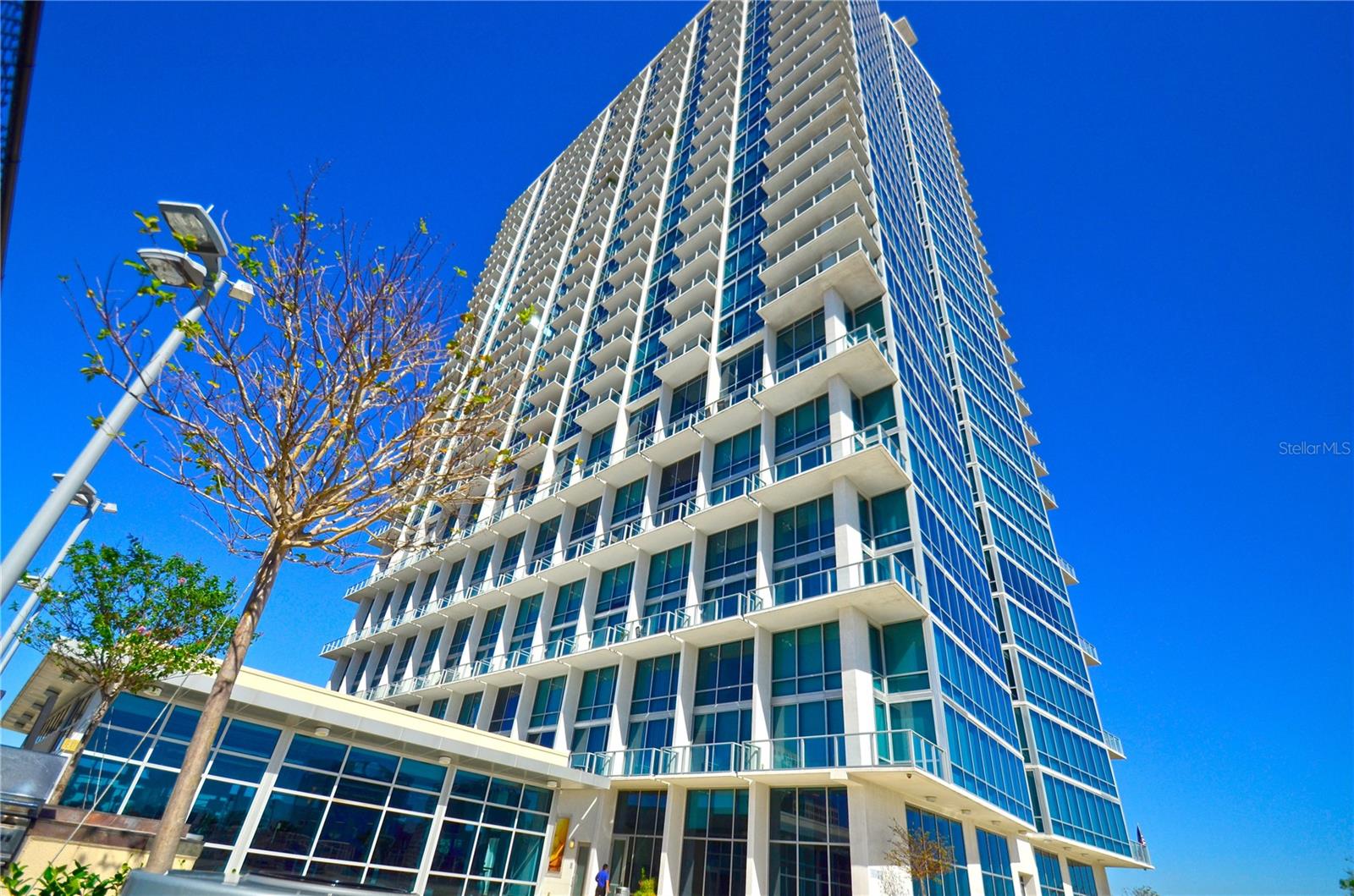 Rare opportunity to own this stunning 14th-floor bi-level loft featuring 1 bedroom, 1.5 bathrooms, and breathtaking lakefront views. Spanning 921 square feet, this contemporary residence is highlighted by floor-to-ceiling glass walls that showcase panoramic views of Downtown Orlando and Lake Eola. Recently updated with elegant wood-look porcelain flooring on the main level, this residence offers a sophisticated blend of style and comfort. Additional upscale finishes include a gourmet kitchen with gas appliances, European-style cabinetry, granite countertops, and one assigned parking space. Residents of The Vue enjoy luxury high-rise living in one of Orlando's most desirable locations, directly overlooking beautiful Lake Eola and just steps from its vibrant dining, entertainment, and outdoor activities. The building offers an impressive 30,000-square-foot amenity deck, including a 5,000-square-foot fitness center, resort-style swimming pool, club room, tennis and basketball courts, outdoor grilling areas, business center, and an elegant lobby staffed with 24/7 concierge and security services. Schedule your private showing today and experience the best of downtown luxury living.