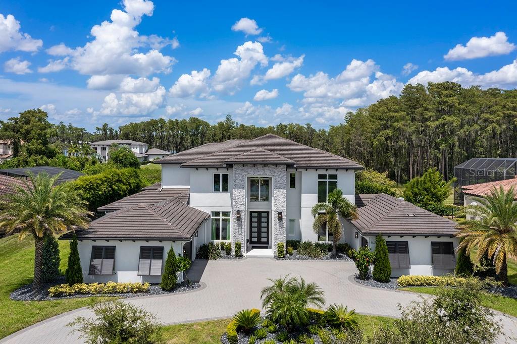 Welcome to this extraordinary Windermere Custom Estate, a true masterpiece of luxury living. Nestled on over an acre of lush land, this sprawling residence offers over 6,000 square feet of sheer opulence. With 5 bedrooms, 5 baths, and 2 half baths, this home is the epitome of elegance and comfort. As you enter, you'll be captivated by the breathtaking views of the verdant green space and the outdoor entertaining paradise that awaits you. Imagine sipping a refreshing drink by the expansive saltwater pool and spa, serenaded by the soothing sounds of the water feature – this is the life you deserve. Step inside, and you'll be greeted by an array of exquisite interior features. Designer lighting, custom window treatments, tray and coffered ceilings, and crown molding adorn the living spaces. Engineered wood floors flow seamlessly throughout, adding warmth and character to every room. Work from home in style with a dedicated home office, or unwind in the media room complete with a wet bar for entertaining guests. This property boasts not one, but two master suites – one on each level – offering unparalleled flexibility and luxury.The gourmet kitchen is a chef's dream, featuring an oversized island with a breakfast bar, pendant lighting, and top-of-the-line appliances. The architectural dream staircase with wood treads and wrought iron spindles adds a touch of grandeur to the space.The main level comprises a Great room/kitchen combo, a spacious dining area, an office, a media room, a convenient laundry room, and a drop zone. Additionally, there's a first-floor master suite and a guest suite.
Venturing upstairs, you'll find the second master suite with two more bedrooms, each with en suite baths. A flex space provides endless possibilities, and the two-story great room adds a sense of grandeur to the upper level. Step outside onto the oversized marble pool deck and discover the full-size summer kitchen – perfect for outdoor gatherings. Pest control misters ensure your comfort, while audio speakers set the mood. An arched water feature and a second-floor balcony overlooking the pool enhance the ambiance. Other notable features include a 2018 roof, gutters, and a generous circular driveway leading to a courtyard with multiple car capacity. This property is currently zoned for Windermere Schools and is conveniently located just steps away from the direct path to Windermere Prep School – say goodbye to carlines! Don't miss the opportunity to make this Windermere Custom Estate your forever home. Experience the height of luxury and schedule your private viewing today!