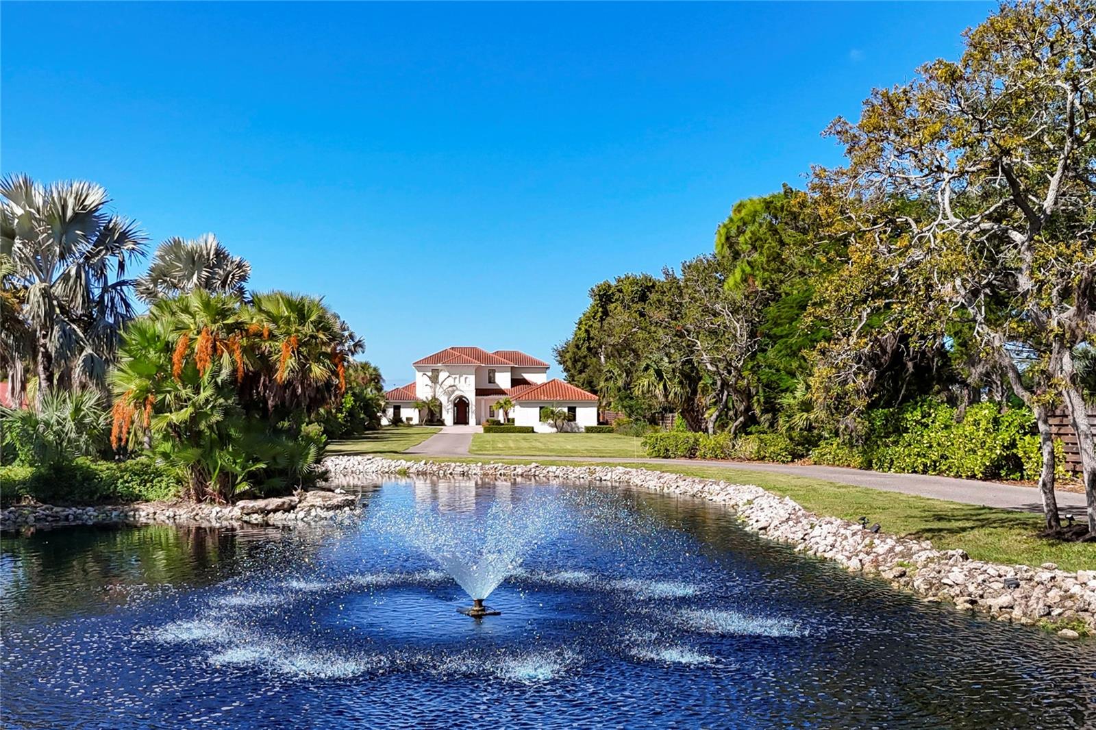 Virtually Staged. PREMIER HIGH-ELEVATION BAYFRONT ESTATE ON 2 PRIVATE ACRES 4 Bedrooms | 5.5 Bathrooms | 6,308 Sq. Ft. | 730 Sarabay Road is a rare opportunity to own two acres of private waterfront property in Osprey. Situated at the end of a long gated drive by a private pond, this expansive estate offers privacy, luxury, and direct boating access to the Gulf through nearby Midnight Pass. Positioned along 100 feet of Little Sarasota Bay frontage, it includes a private dock and 15,000-lb boat lift. Inside, the residence provides over 6,300 square feet of living space, soaring ceilings, walls of windows, and sweeping bay views. Wide-plank oak and floor-to-ceiling hurricane-impact windows frame generous living spaces designed for entertaining and an open-plan gourmet kitchen. The primary suite includes a spa-inspired bath and spacious walk-in closets. Upstairs, three en suite bedrooms feature views over the bay; an additional room offers flexibility as a sitting room or fifth bedroom. Outside, a large travertine terrace, resort-style pool and hot tub, propane fire pit, and broad bayside lawn showcase Sarasota’s brilliant sunsets. A four-car attached garage and air-conditioned, detached three-car garage offer space for car collectors, or for an artist’s studio or home gym. Ideally located between Sarasota and Venice, the home has easy access to Siesta Key and Nokomis beaches as well as to the many cultural attractions of Sarasota’s downtown. Additionally, the home has a documented history of no flooding, water intrusion, or hurricane damage, providing significant peace of mind. This bayfront estate is a unique combination of lush acreage, secure elevation, boating access, and luxury coastal living—a complete waterfront lifestyle.