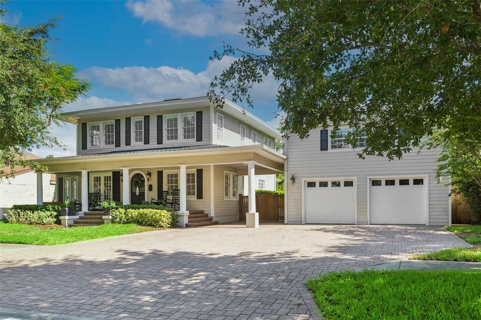 Extensively restored, this 1925 historic gem sits on an expansive 89' x 160' lot along a picturesque, tree-lined street in Parkland Estates/New Suburb Beautiful. The property features a 3,034-square-foot main residence with 4 bedrooms, 2.5 bathrooms, and a dedicated office, plus a detached 2-car garage with a 624-square-foot apartment above.   Preserving the beauty of its historic architecture while incorporating today's most desirable features, the home welcomes you with a paver driveway, manicured walkway, and classic columned front porch with an arched entry. Inside, original character shines through with solid oak floors, a beautiful staircase, and an abundance of natural light.  The thoughtfully designed floor plan of the early 1900’s includes a spacious formal living room with French doors opening to the front porch, a sunlit office or flex space, and a formal dining room with elegant chair rail molding. The inviting family room, highlighted by transom windows and French doors, flows seamlessly into the fully renovated kitchen (2018), creating the perfect space for everyday living and entertaining.  Designed for both style and functionality, the kitchen features a 6-burner gas range with pot filler and custom range hood, Sub-Zero refrigerator, island with seating for 3–4 and a built-in wine refrigerator, farmhouse sink, quartz countertops, ceiling-height cabinetry, subway tile backsplash, a built-in China cabinet with glass-paneled doors, and a spacious walk-in pantry. French doors lead to the screened back porch, offering the ideal setting for outdoor dining, relaxing, or enjoying views of the spectacular backyard.  The oversized backyard is a private retreat with a saltwater pool, expansive green space, and endless opportunities for entertaining, play, or future enhancements.  Upstairs, the generous primary suite features a walk-in closet and French doors opening to a large second-floor balcony overlooking the lush backyard. The spa-inspired primary bathroom includes a freestanding soaking tub, oversized walk-in shower with dual showerheads, private water closet with bidet, and a linen closet. Three additional bedrooms share a beautifully renovated full bathroom with a tub/shower combination.  The detached oversized garage includes a private upstairs apartment with its own entrance, offering a spacious studio layout complete with a kitchenette, full bathroom, and generous living area—ideal for guests, in-laws, a home office, or perhaps even rental income potential.  Other features include:  plantation shutters; crown molding; closet systems; from past permits: 2019 & 2020 roof, 2018 kitchen, bathroom 2017, 2014 A/C.  Located in one of South Tampa's most sought-after neighborhoods, this exceptional home offers the rare combination of historic elegance, modern luxury, and an unbeatable location. Enjoy walking distance to SoHo, Bayshore Boulevard, and Hyde Park Village, with convenient access to Downtown Tampa, Tampa International Airport, and the bridges to St. Petersburg.
