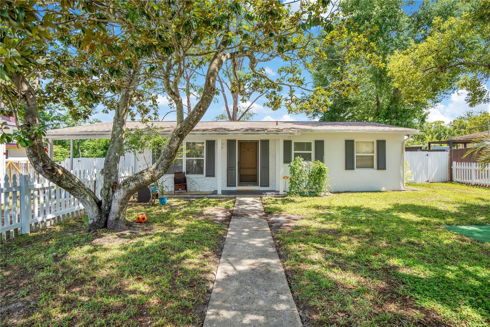 WHITE PICKET FENCE DREAM HOME WITH NO HOA! Full of charm, character, and curb appeal, this cozy, move-in-ready 2-bedroom, 1-bath home sits on a rare oversized fenced lot and features fresh interior and exterior paint, a newer roof, and a spacious glass-enclosed family room that adds valuable living space.

Step inside to a bright and welcoming floor plan filled with natural light, creating a warm and comfortable atmosphere from the moment you enter. The cozy living area flows effortlessly into the kitchen and dining space, making everyday living both practical and enjoyable.

One of the standout features of this home is the large glass-enclosed family room, providing flexible space for entertaining, a home office, hobbies, a playroom, or simply relaxing while enjoying views of the backyard.

Outside, you'll find plenty of room for pets, gardening, outdoor gatherings, and future projects on the oversized fully fenced lot. The classic white picket fence adds timeless appeal and creates the welcoming atmosphere so many buyers dream about.

Conveniently located just minutes from I-4, shopping, restaurants, medical facilities, parks, and entertainment. Enjoy easy access to Orlando and Daytona Beach, both approximately 30 minutes away.

Whether you're purchasing your first home, downsizing, or searching for an affordable Florida retreat, this charming property offers comfort, convenience, character, and exceptional value.