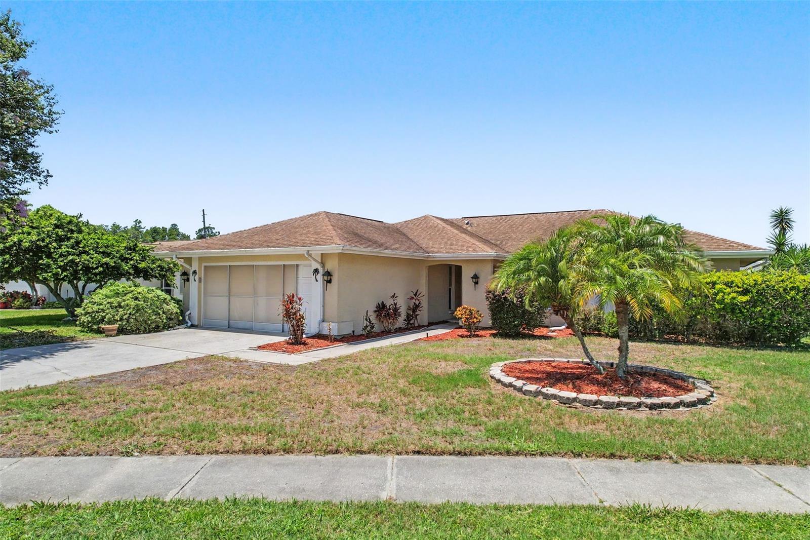 Get ready to enjoy the Florida lifestyle in a home that feels like new! Beautiful, split open floor plan home is not only light and airy, but very well designed. This 2/2 home with bonus den/flex room (which can easily be converted to a 3rd bedroom) has high ceilings, and a wonderful open kitchen any chef would love to entertain in. Solid wood cabinets, a dining room area featuring bay windows and a great view of your private back yard. Central, large living room features a real wood-burning charming fireplace. The huge primary bedroom features a large walk in closet, an en-suite double sink bathroom with lots of storage space, and sliding glass doors to the back lanai that lead to your own private spa with a cover. The second large bedroom on the opposite side of the home features a huge double closet! Enjoy your privacy! You'll love entertaining and relaxing with beautifully landscaped views when you step out of the triple sliding-glass doors to your enclosed and screened in, oversized back patio lanai with walk in storage that offers plenty of privacy! Awesome ceiling fans and lights throughout to keep you nice and cool. There's plenty of room for storage in the oversized 2-car garage. Time to have fun? Hit the community clubhouse or pool to cool off and relax! Located in a highly rated school district in the established and desirable community of Fairway Springs near Trinity, you will be so close to all you need: shopping, top-rated hospitals and schools, parks, fine dining, entertainment, historic downtown New Port Richey, award-winning beaches, and the highway to Tampa. Wonderful, peaceful, established fine community.