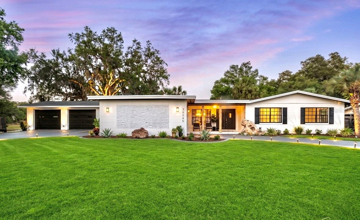 TRUE LAKEFRONT LIVING ON A RARE 0.81-ACRE DOUBLE LOT WITH APPROXIMATELY 360 FEET OF COMBINED LAKE AND CANAL FRONTAGE!

Welcome to one of the most unique waterfront properties in Central Florida. Situated on Little Lake Tryon, this beautifully refreshed modern farmhouse offers water views from multiple sides of the property, exceptional privacy, and NO HOA restrictions.
Set on a 0.81-acre double lot surrounded by water views, this unique property features approximately 360 feet of combined lake and canal frontage, creating an exceptional outdoor setting that is difficult to find.

Inside, you’ll find 3 bedrooms, a flexible bonus room, 2 bathrooms, and an open-concept floor plan designed for comfortable living and entertaining. The heart of the home features a stunning 13-foot quartz waterfall island with a centered gas range, a butler’s pantry with wine cooler, premium porcelain flooring, and a modern electric fireplace.
The spacious primary suite offers a huge walk-in closet, smart mirror, and a spa-inspired LED rain shower.

Step outside and enjoy your own private Florida retreat featuring a sparkling pool, pergola with swing, fire pit, covered patio pre-plumbed for a future summer kitchen, and plenty of space to relax while taking in the peaceful waterfront scenery. A fishing boat is included, allowing you to enjoy lake life from day one.

Recent improvements include interior and exterior paint, flooring, kitchen and bath enhancements, pool equipment and lighting, smart locks, and more. HVAC was replaced in 2023.

Conveniently located just minutes from The Villages, shopping, dining, golf, and everyday conveniences. The property also appraised above the current asking price, creating an outstanding opportunity for the next owner.

Schedule your private showing today.