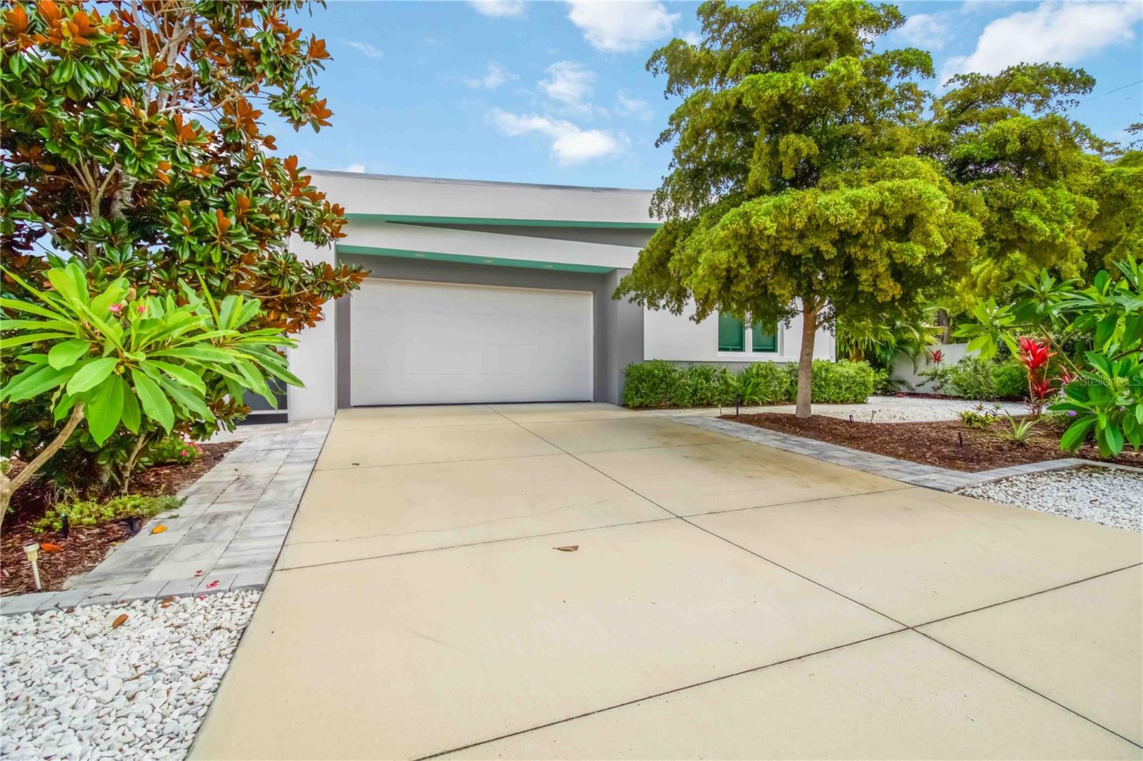 CUSTOM-BUILT by Milano Homes in 2019, this CONTEMPORARY POOL HOME combines modern design, exceptional construction, and an unbeatable Arlington Park location. Situated on a private corner lot just blocks from Sarasota Memorial Hospital and minutes to Downtown Sarasota, Southside Village, Bayfront Park, the Legacy Trail, and Siesta Key Beach, this residence offers the ultimate Sarasota lifestyle. Inside, SOARING CEILINGS and an open-concept floor plan create a bright, airy living space designed for both everyday comfort and entertaining. The sleek EUROPEAN-STYLE KITCHEN showcases quartz countertops, glossy cabinetry, NATURAL GAS cooking, a large center island, pantry, and smart pull-out storage solutions. The spacious primary suite includes custom closet built-ins and an en suite bathroom featuring dual sinks and a walk-in shower. Enjoy seamless indoor-outdoor living with a SCREENED LANAI overlooking the PRIVATE POOL, mature landscaping, and privacy wall. A natural gas connection for grilling makes outdoor entertaining effortless year-round. Built for efficiency and peace of mind with CONCRETE BLOCK CONSTRUCTION, IMPACT WINDOWS AND SLIDERS, SMART HOME FEATURES, NATURAL GAS SERVICE, WHOLE-HOUSE GENERATOR, and an attached two-car garage. An incredible opportunity to own a newer custom-built home in sought-after Arlington Park, offering lock-and-leave convenience, contemporary style, and close proximity to Sarasota's best dining, shopping, healthcare, cultural attractions, and world-renowned beaches.
