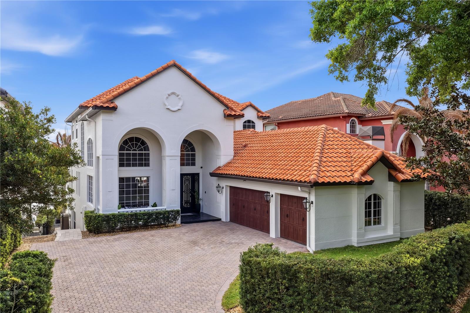 Perfectly positioned on the shores of Big Sand Lake, steps from Restaurant Row and the beating heart of Orlando's most coveted corridor. This breathtaking 5,901 SqFt custom-built masterpiece delivers a lifestyle that is simply unmatched. Six bedrooms, six baths, and three magnificent stories of sun-drenched, water-kissed living await. Soaring ceilings and walls of oversized windows flood the open-concept interior with natural light, while gleaming marble floors carry you effortlessly through every level. The grand entry, framed by double glass doors with custom iron detailing, sets the tone from the moment you arrive. Inside, the chef's kitchen is nothing short of spectacular: premium Viking appliances, a gas cooktop island, custom two-tone cabinetry, and quartz countertops built to impress even the most discerning entertainer. The primary suite serves as a true retreat with panoramic lake views through floor-to-ceiling windows, custom California closet with built-ins and a private balcony. Spa-inspired en-suite features freestanding soaking tub, rainfall shower, dual vanity, and a private dry sauna. Upstairs, three additional bedrooms and a spacious loft with balcony access offer endless flexibility for family, guests, or a home office.
The lower level is where entertainment reaches new heights: a dedicated home theater with a built-in projector system, a curated wine cellar, and a fully appointed wet bar complete with dishwasher, refrigerator, and kegerator, all anchored by a dramatic textured stone accent wall. Whether hosting an intimate gathering or a full-scale celebration, this home handles it with effortless style.
Step outside and enter your own private resort. The travertine pool deck stays cool underfoot while the heated pool and spa shimmer with lakefront views. Two fully equipped summer kitchens with built-in grills, sinks, and beverage fridges, a gas fire pit, motorized retractable screened patios, and covered outdoor living area make every evening feel like a vacation. From your private dock with boat lift you'll watch Disney and SeaWorld light up the sky each night as the International Drive Ferris wheel glows on the horizon.
Situated in a guard-gated community with tennis courts, a fitness center, and lush professional landscaping, all wrapped in Mediterranean-inspired architecture with stunning curb appeal. A 3-car garage and expansive paver driveway complete the picture.
This is more than a home, it's a private lakefront estate where luxury, entertainment, and the magic of Orlando converge every single day. Opportunities like this are extraordinarily rare. Schedule your private showing today.