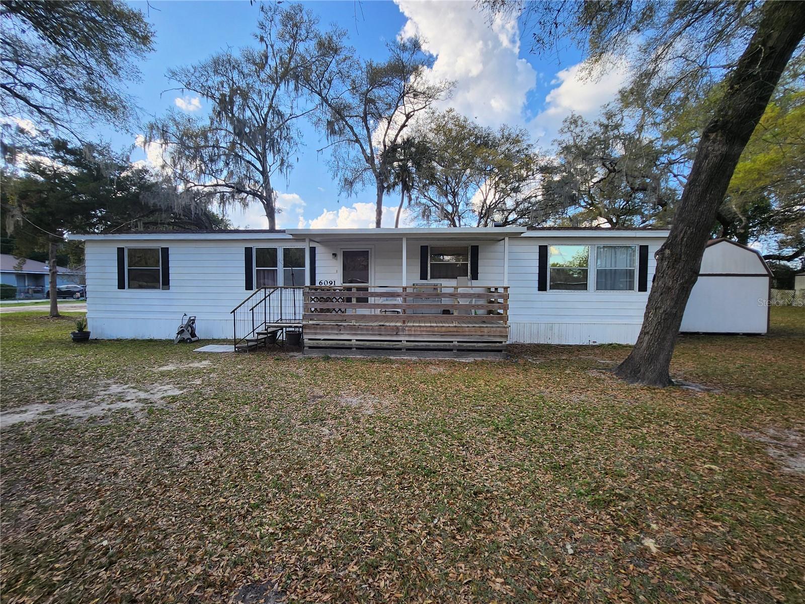New roof in 2021  This beautiful private corner lot features a spacious 3/2 manufactured home on 1/4 acre
nestled under gorgeous oak trees. Living room, dining room, kitchen with new oven with an eat-in bar/counter
area, all new remodeled guest bathroom, laminate flooring throughout with a separate laundry room inside. A
brand new 12x16 wooden "barn" style storage unit for all of your storage needs sit next to the home. Enjoy a
relaxing evening sitting around your own fire pit! No HOA fees. Plenty of room for a pool or swing set. Great
location with easy access to Ocala and The Villages Community! Stores and shops located conveniently right
around the corner. This would be a smart investment, a perfect home for a first-time buyer, or someone looking
for a simple life style. Riding lawn mower will stay with the sale of the home along with some tools that are
inside the shed. Come take a look!