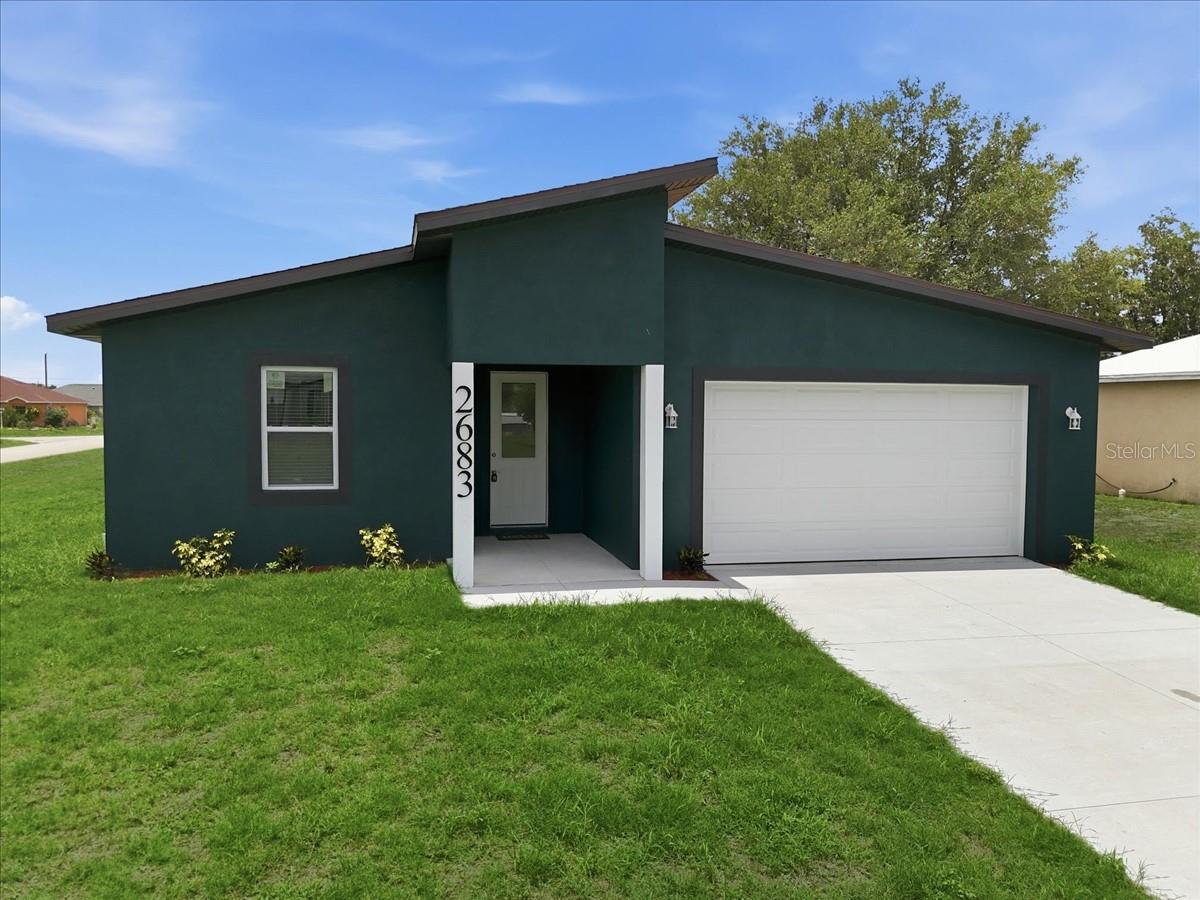 One or more photo(s) has been virtually staged. From the moment you step through the impact-rated front door into soaring 10-foot ceilings and 8-foot interior doors, this 3-bedroom, 2-bath home with a den feels immediately spacious and intentional. Rich ceramic tile plank runs throughout, complemented by 5¼" baseboards and recessed lighting that give every room a finished, custom feel. The kitchen delivers where it counts, quartz countertops, soft-close wood cabinets with dovetail construction, and stainless steel appliances make it as functional as it is beautiful. The generously oversized primary suite well beyond the standard bedroom footprint offers a walk-in closet and a private en-suite with dual sinks and a tiled shower. All bedrooms and the living room are outfitted with ceiling fans and fitted blinds. Impact windows, sliders, and doors provide year-round peace of mind. Unwind on the covered lanai or relax on the welcoming front porch, comfort lives here, inside and out. The oversized 2-car garage with a convenient side entry door completes the package.