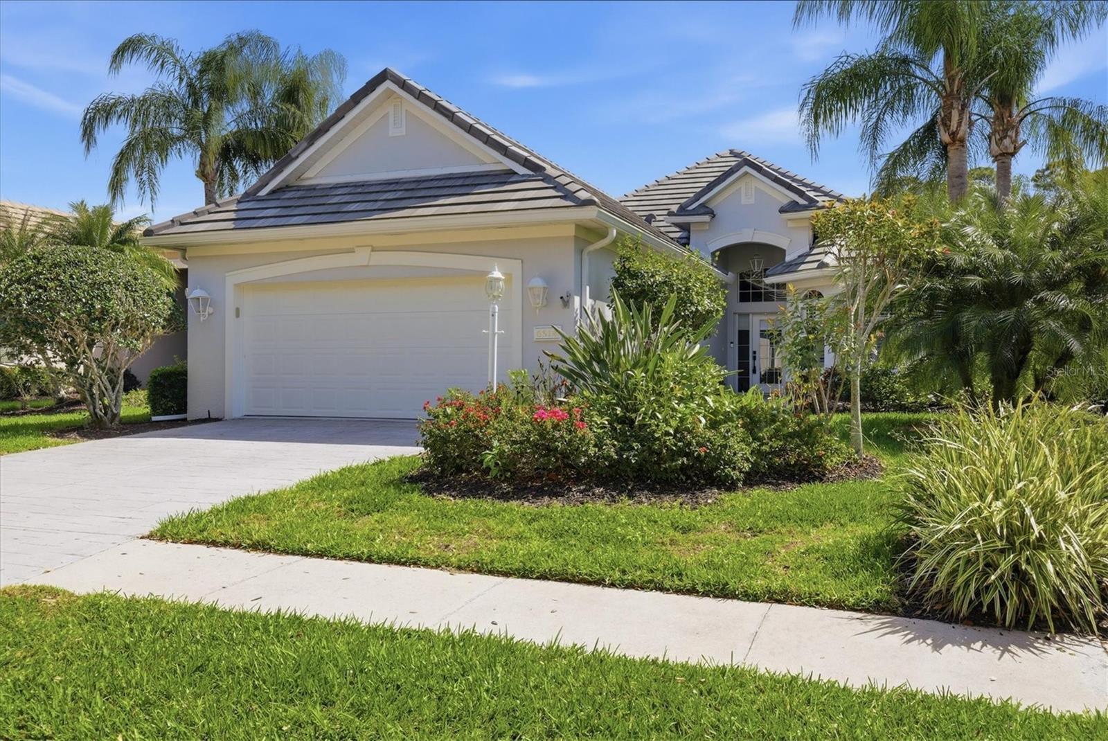 This residence has undergone an extensive renovation of over $200,000, giving it the look and feel of a new home. Major improvements include a TOTALLY REMODELED KITCHEN, NEW FLOORING THROUGHOUT, NEW TILE ROOF, NEW GUTTERS, replaced HVAC system and new water heater. This beautifully renovated single-family home in the desirable maintenance-free Muirfield neighborhood offers the rare combination of luxury updates, privacy and a short distance to the community pool. Tucked away on a quiet cul-de-sac, the home enjoys open lake and preserve views, creating a peaceful backdrop with frequent wildlife sightings.  Inside, the home showcases new porcelain tile flooring throughout, all new lighting and ceiling fans, and a freshly painted interior and exterior with enhanced landscaping. A Tesla EV charging system has also been installed for modern convenience. Go through the glass front entry into a bright, open floor plan designed for effortless indoor-outdoor living. The great room features a striking electric fireplace framed with stone and shiplap detailing and a wall of disappearing sliding glass doors that open seamlessly to the outdoor living area. The resort-style outdoor space is designed for entertaining and relaxation, featuring a saltwater pool and spa, a covered lanai with wood ceiling, outdoor kitchen, and a custom tiled feature wall with flat-screen TV, ideal for enjoying Florida’s year-round lifestyle. The fully renovated gourmet kitchen is a standout, offering new soft-close shaker cabinetry, stone countertops, new appliances and designer backsplash tile. It flows naturally into the casual dining nook with bay windows, while the formal dining room sits just off the great room for easy entertaining. Guests and family are comfortably accommodated with two additional bedrooms, including one with a built-in Murphy bed, along with a beautifully updated full guest bath. The primary suite provides a private retreat with a spacious sleeping chamber, walk-in closet with custom organizers and an additional walk-in closet in the primary bath for extra storage. The completely renovated primary bathroom showcases double vanities with elegant stone countertops, dramatic large-format tiled walls, and an expansive walk-in shower featuring dual rain shower heads, river stone flooring and sleek frameless glass enclosure. Additional highlights plantation shutters, a renovated laundry room with new cabinetry, sink and laundry tub, making everyday tasks functional and stylish. With extensive upgrades, serene lake and preserve views, and a prime location within Lakewood Ranch Golf & Country Club, this home is move-in ready. A complete detail list is available. Optional membership opportunities are available at Lakewood Ranch Golf & Country Club, offering an exceptional lifestyle with no mandatory membership. Members enjoy access to four 18-hole championship golf courses, 18 Har-Tru lighted tennis courts, pickleball courts, a state-of-the-art fitness center, Junior Olympic-size pool and aquatic center, and luxurious clubhouses featuring dining, social events and activities. In Lakewood Ranch, the #1 top-selling planned community in the country, residents benefit from abundant amenities including parks, scenic walking trails, top-rated schools, and an array of shopping and dining options. Great location with proximity to dining, beaches, UTC mall, SRQ airport and downtown Sarasota.
