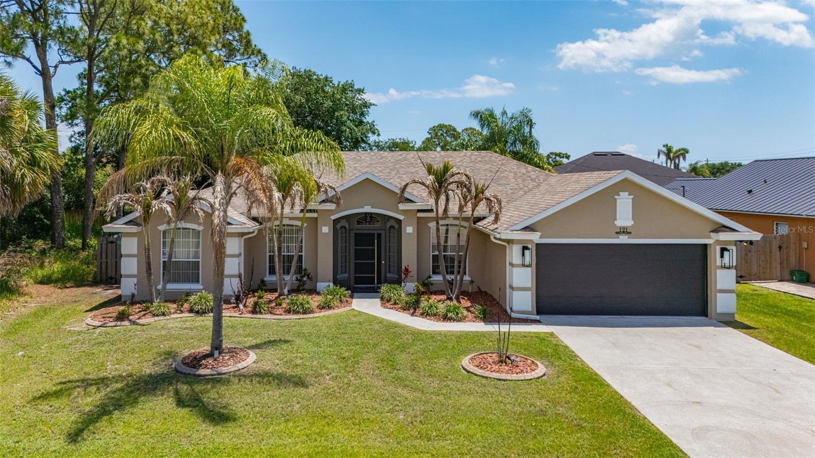 Welcome to 121 Nadell Avenue NW, a beautifully maintained 4 bedroom 3 bathroom Florida home offering the perfect blend of comfort, style, and privacy. Situated on an oversized lot with lush tropical landscaping and no immediate neighbor to one side, this move-in ready property makes an unforgettable first impression from the moment you arrive. Step inside through the screened front entry and discover a bright, open layout featuring soaring ceilings, elegant tile flooring, and spacious living and dining areas designed for both everyday living and entertaining. The updated kitchen is the heart of the home, showcasing modern gray cabinetry, granite countertops, stainless steel appliances, stylish backsplash details, and a breakfast bar overlooking the main living spaces.Enjoy multiple dining and gathering areas, including a cozy breakfast nook with views of the backyard and pool area. Large sliding glass doors create seamless indoor-outdoor living and fill the home with natural light.

The spacious primary suite and secondary bedrooms provide comfort and flexibility for families, guests, or a home office setup. Outside, the private backyard offers endless possibilities for relaxing, entertaining, or enjoying the Florida lifestyle year-round. Conveniently located near shopping, dining, parks, and major roadways, this home combines peaceful living with everyday convenience. Whether you're looking for your first home, seasonal retreat, or forever home, 121 Nadell Avenue NW is one you won't want to miss.