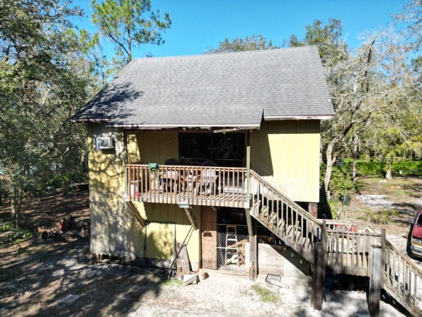 LOOKING FOR CASH ONLY - Riverfront Retreat on 5.3 Acres – Horse-Friendly, Private, and No HOA. Discover your own private oasis on this fully fenced and cross-fenced 5.3-acre riverfront property. Ideal for equestrians, nature lovers, or anyone seeking peace and privacy, this rare find includes a one-stall 24x23 barn with a feed/tack room, a horse paddock, and a 12x24 storage shed — all ready for your animals, hobbies, or gear. The charming 2001 stilt home sits high and dry on approximately 1.8 acres of elevated land, safely out of the floodplain. Designed with an open-concept layout, the home features a cozy loft-style primary bedroom upstairs that overlooks the living area below. A half bath in the loft includes a working toilet, with plumbing already in place to add a sink. Downstairs, you’ll find a functional full bathroom, an efficient kitchen, and a bright living room with easy access to both the ground-level laundry room and the welcoming front porch. Enjoy practical perks like a 4" well, WREC electric service, and a mini-split system. The roof and HVAC system appear to be in good working order. Access is available via Tworut Road, with additional ingress possible from the county line easement. No deed restrictions, no HOA, and no CDD means you can enjoy the freedom to live how you want. Whether you're looking for a weekend retreat, homestead, or riverfront getaway, this unique property delivers peace, privacy, and plenty of potential.