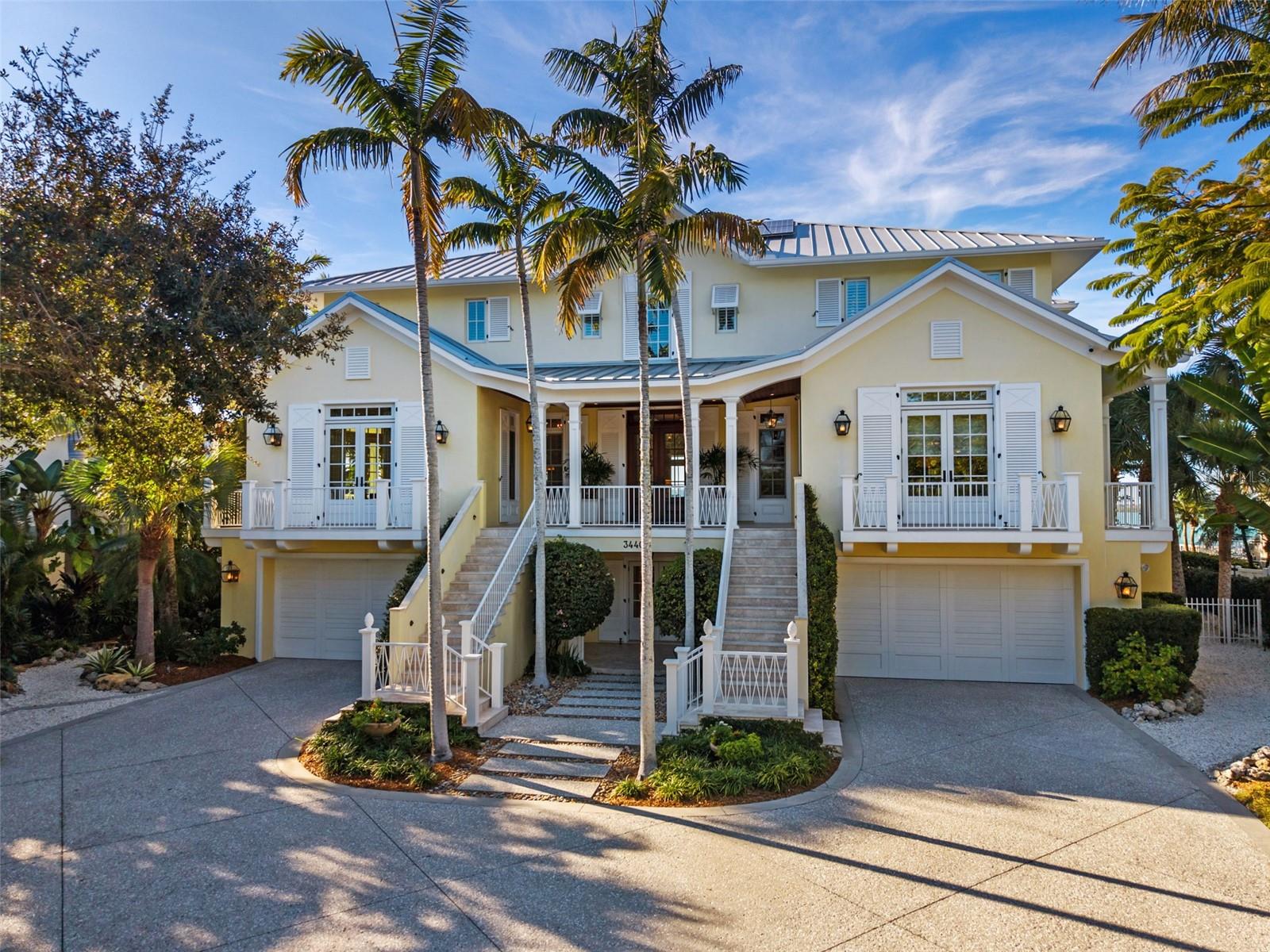 Discover a rare opportunity to enjoy pristine Gulf views, aquamarine waters, and a deep-water dock on the very North end of Siesta Key, just minutes to downtown Sarasota.  One of Siesta Key’s most stunning and secluded waterfront sites — a residence offering a rare combination of historic significance, panoramic views of Big Pass, and exceptional structural integrity. Located approximately 200 feet south of civic leader Henry Higel’s early 20th-century Higelhurst Hotel, the pioneering developer’s beloved coastal breezes still beckon family and friends to enjoy swimming, water sports, boating, fishing, shoreline picnics, and direct, no-bridge access to the sparkling Gulf. Multiple covered porches and expansive windows provide front-row views of vivid sunsets and frolicking dolphins. Named for its pineapple stair finials symbolizing welcome, the Pineapple House was built in 2008 with an engineer-homeowner’s meticulous eye for detail. Constructed on pilings and grade beams, the home is set on a 31,293-square-foot lot and encompasses 6,596 square feet under air, with more than 13,000 total square feet. Designed by Diane Weinman with a refined Boca Grande aesthetic and built by ML Collingwood, the dwelling projects enduring quality, thoughtful engineering, and elevated coastal living. Enter through the impressive double doors to a sensual treat of symmetry and light. Main-level windows crowned with transoms frame views of the tropical blue sky. Walnut engineered flooring, Jerusalem stone, eight-foot doors, custom millwork, and generous closets enhance both functionality and beauty throughout. Scaled to feel both warm and elegant, the interiors are enriched with refined finishes and thoughtful architectural detailing. Living spaces encompass a formal dining room with butler’s pantry, living room, bookcase-lined library or sitting room, private office with built-in desk and cabinetry, dedicated home gym, and a flexible gathering room. A second primary or guest suite on the main level offers a private sitting area, breakfast bar, screened porch, and picture-perfect water views. An elevator conveniently serves all three floors. The chef’s kitchen anchors the main living areas with honed granite countertops, Sub-Zero appliances, custom Campbell cabinetry, and a walk-in pantry, opening to casual dining spaces and sun-filled outdoor porches. Upstairs, the primary suite is a tranquil retreat featuring a spa-inspired bath, oversized walk-in closet, shaded terrace, and outdoor shower. The expansive dock features two boat lifts: one 22,000-pound lift suitable for a 32- to 36-foot vessel and a second 10,000-pound lift. A humidity-controlled four-car tandem garage and a separate two-car garage accommodate up to six vehicles along with extensive marine and recreational gear. Solar panels and a 30kW generator underscore the home’s focus on energy efficiency and resilience. Outdoor living is highlighted by a 20,000-gallon heated saltwater lap pool surrounded by Shellcrete patios and Ipe decking. A perched beach with fire pit and swings welcomes gatherings overlooking Big Pass, while a 75-foot rear setback ensures privacy within a lushly landscaped yard. Rich in history, resilient and luxurious, intimate and refined, this is Sarasota waterfront living at its most authentic and coveted.