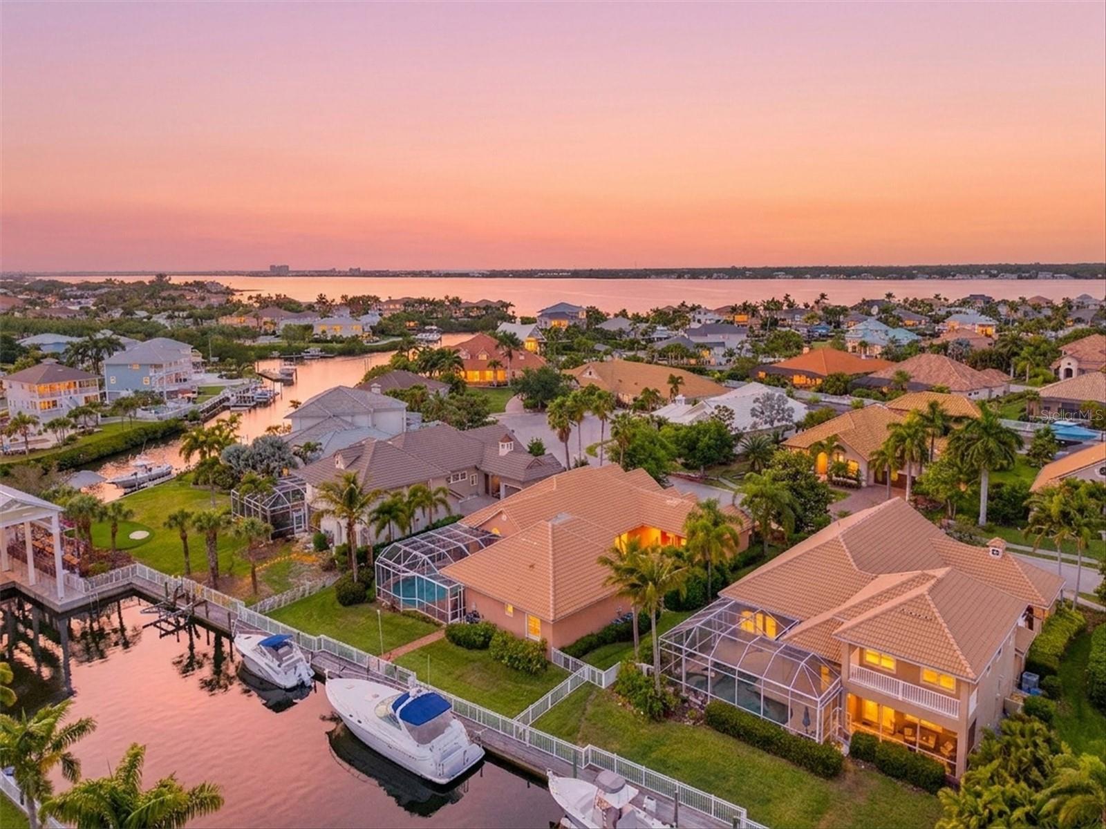 Live the Ultimate Waterfront Lifestyle in this premier custom residence located in the gated boating community of Harbour Walk. A former Bamboo Model Home showcasing an inspired, thoughtfully designed floor plan and over 3,100 sq. ft. of luxurious single-level living. Step through the grand vestibule and be immediately captivated by soaring vaulted ceilings accented with double designer paddle fans. A private den with elegant French doors is perfectly situated at the front of the home, ideal for a home office or quiet retreat. Designed for both refined living and effortless entertaining, the formal living and dining rooms transition seamlessly into the inviting great room with fireplace all centered around tranquil water views. Throughout the home, you’ll find exquisite custom millwork, fresh interior paint creating a light and bright ambiance, and rich engineered wood flooring. Premium appointments include crown moldings,10' Ceilings, plantation shutters, impact windows, new electronic window blinds, an insulated attic, and dual 16 SEER HVAC systems with Air Halo purifiers. The custom kitchen is the heart of the home, designed for both beauty and function, featuring quartz countertops, classic subway tile backsplash, stainless vent hood, 5-burner gas range, wine refrigerator, walk-in pantry with custom wood shelving, warm wood cabinetry, and a spacious center island all enhanced by abundant natural light. The charming café area offers sliding glass doors on two sides, seamlessly blending indoor and outdoor living. A thoughtfully designed split-bedroom layout offers two guest bedrooms with a shared bath for privacy and comfort. The primary suite is a true retreat, privately situated with dual custom walk-in closets and a spa-inspired bath featuring luxurious finishes. Additional highlights include a fully fenced yard perfect for pets and a spacious three-car garage offering ample storage and flexibility. Step outside to your private backyard oasis complete with an expansive paver lanai, sparkling heated pool and spa, and a dedicated space ready for your dream outdoor kitchen. Whether enjoying quiet mornings or hosting gatherings, this serene waterfront setting delivers the best of Florida living. For boating enthusiasts, the private dock with approximately 90 feet of water frontage includes electric, water, and lighting—providing direct access to the Intracoastal waterways, nearby islands, waterfront dining, and exceptional fishing.Strategically priced to outperform competing waterfront properties, this expansive 3,103 sq ft residence presents a rare opportunity to secure premium waterfront living with exceptional value. Ideally located, this home provides convenient access to the best of the Gulf Coast—from pristine white sand beaches and vibrant cultural venues to fine dining, sporting events, and world-class shopping at UTC Mall and Ellenton Premium Outlets. With easy access to I-75, Sarasota, St. Petersburg, and Tampa are all within reach. Harbour Walk is a gated, secure boating community with no CDD fees ,low HOA fees, and cable TV including HBO MAX  and High Speed Internet included—offering a truly exceptional lifestyle. Come experience the beauty, comfort, and elegance of waterfront living—your dream home on the river’s edge awaits.