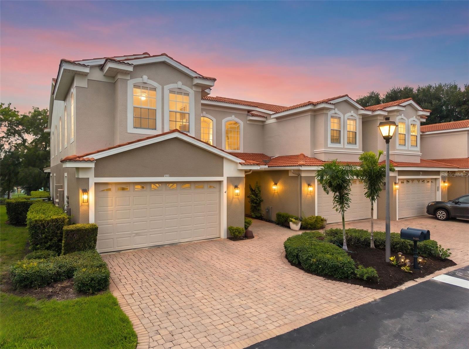 Rare opportunity to own this beautiful 3-bed, 3-bath END-UNIT townhome with a 2-car garage, privately situated at the back of the highly sought-after gated community of Villas of San Marino. Just steps from the scenic Pinellas Trail and within walking distance of popular restaurants, live music, local breweries, and year-round community events, you'll enjoy the very best of Florida living.  Inside, an impressive foyer with soaring 22-foot ceilings leading to the stunning hardwood staircase, elegant 8-foot doors throughout, abundant natural light, create an unforgettable first impression. The open-concept floor plan centers around a beautifully appointed chef's kitchen featuring granite countertops, stainless steel appliances, 42-inch cabinetry, a spacious walk-in pantry, and bar seating perfect for entertaining. A desirable split-bedroom layout includes a private FIRST-FLOOR BEDROOM and full bath, ideal for guests, a home office, or multi-generational living, while two additional bedrooms are located upstairs. The expansive primary suite serves as a private retreat, complete with its own balcony overlooking the baseball fields and Gulf water views through the trees, a large walk-in closet, and a spa-inspired ensuite bath with dual granite vanities, a walk-in shower, and a separate garden tub. French doors open to the recently added oversized screened lanai, seamlessly blending indoor and outdoor living to enjoy year-round. Residents enjoy a truly maintenance-free lifestyle with a reasonable HOA fee that INCLUDES the tile roof, exterior painting, cable, internet, lawn maintenance, hedge trimming, and trash service. The community also offers a heated pool for year-round enjoyment and 32 guest parking spaces for added convenience. Zoned for highly rated Palm Harbor University High School, Palm Harbor Middle School, and Ozona Elementary School, this location is ideal for families. Outdoor enthusiasts will appreciate being just a five-minute bike ride to Pop Stansell Park with its kayak launch, fishing pier, playground, and waterfront amenities, while Honeymoon Island, Wall Springs Park, charming downtown Dunedin, and award-winning Gulf beaches are all just minutes away via the Pinellas Trail. Best of all, this home is located high and dry with NO FLOOD INSURANCE required. Offering an exceptional blend of luxury, location, and low-maintenance living, this is a rare opportunity you won't want to miss. Call today!