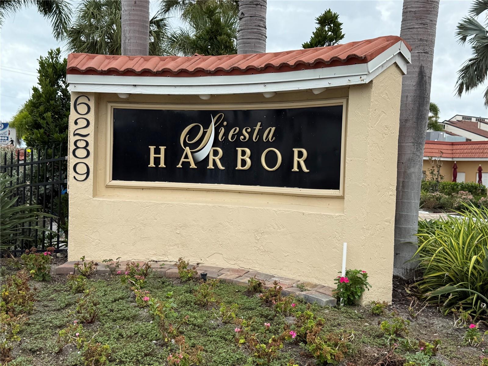 This second floor 2-bedroom, 2 bath condo is located in the Marlin House in the 55+ community of wonderful Siesta Harbor! This unit offers an open floor plan with plenty of light.  Step out onto one of the balcony’s to view the peaceful water, boats going by and you may see dolphins playing while you are enjoying your morning beverage.  This community offers more than just serene water views.  Included in the many amenities are a heated pool, shuffleboard, library and a fitness area.  Feel free to participate in movie night, Tai Chi and Happy Hour along with many other activities offered at the clubhouse.  Are you a boater?  Siesta Harbor is one of the few condos on Siesta Key that offers a boat dock with deep water, for those interested in this bonus extra.  If you wish to walk to the beautiful Siesta Key beach, voted best beach in the USA and the world, private access right across the street through a deeded access.
Siesta Harbor keeps its grounds and buildings well maintained, recently updated with new roofs and updated common areas.  This unit is a must have, with the deep water of the Intracoastal Waterway right in your backyard, the peaceful and serene atmosphere of the area, the beautiful beach just a shore walk away and it can be an income producer should that be something you want to consider.