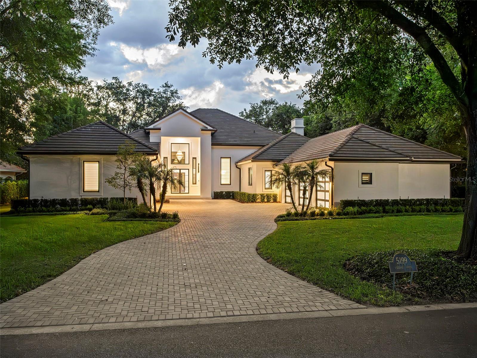 Set within the gates of renowned Isleworth, this beautifully reimagined golf-front estate presents an exceptional opportunity to experience refined Central Florida living at its finest. Perfectly positioned along Isleworth’s celebrated championship golf course, the residence captures sweeping views of the fourth fairway while offering the privacy, comfort, and sophistication synonymous with the community’s distinguished lifestyle.Thoughtfully renovated and impeccably maintained, the home encompasses more than 6,600 square feet of combined indoor living and covered outdoor space, where contemporary finishes, designer lighting, and warm architectural details create an atmosphere that is both elegant and inviting. Every space has been intentionally curated—from the centrally located gourmet kitchen to the well-appointed utility spaces, resulting in a residence designed for effortless everyday living and elevated entertaining alike.The flexible floor plan offers exceptional versatility to suit a variety of lifestyles, accommodating configurations of up to six bedrooms, or alternatively a combination of bedrooms, office space, fitness room, or additional gathering areas. Six full baths and one half bath are finished with timeless materials and meticulous attention to detail throughout.At the heart of the home, the designer kitchen features sleek white cabinetry, quartz countertops, stainless steel appliances, and seamless connectivity to the expansive family room and casual dining area. Large glass openings invite natural light indoors while providing direct access to the screened lanai and resort-style pool environment beyond.The private primary suite serves as a luxurious retreat, highlighted by porcelain plank flooring, a spa-inspired bath with freestanding soaking tub and walk-in shower, and an oversized custom walk-in closet. Additional guest suites provide comfort and flexibility for family and visitors, while the home’s four-car garage and expansive motor court offer abundant space for automobile enthusiasts and guests alike.Outdoors, the estate transforms into a true private sanctuary. A newly redesigned saltwater pool and spa are enclosed within a custom lanai structure and complemented by an expansive new pool deck, creating a year-round setting for relaxation and entertaining. Lush landscaping, a fenced rear lawn, and panoramic golf course vistas further enhance the sense of serenity and exclusivity.Blending timeless elegance with modern livability, this exceptional Isleworth residence offers a rare combination of spacious design, privacy, and premier golf-front surroundings within one of the finest golf club communities in the world.