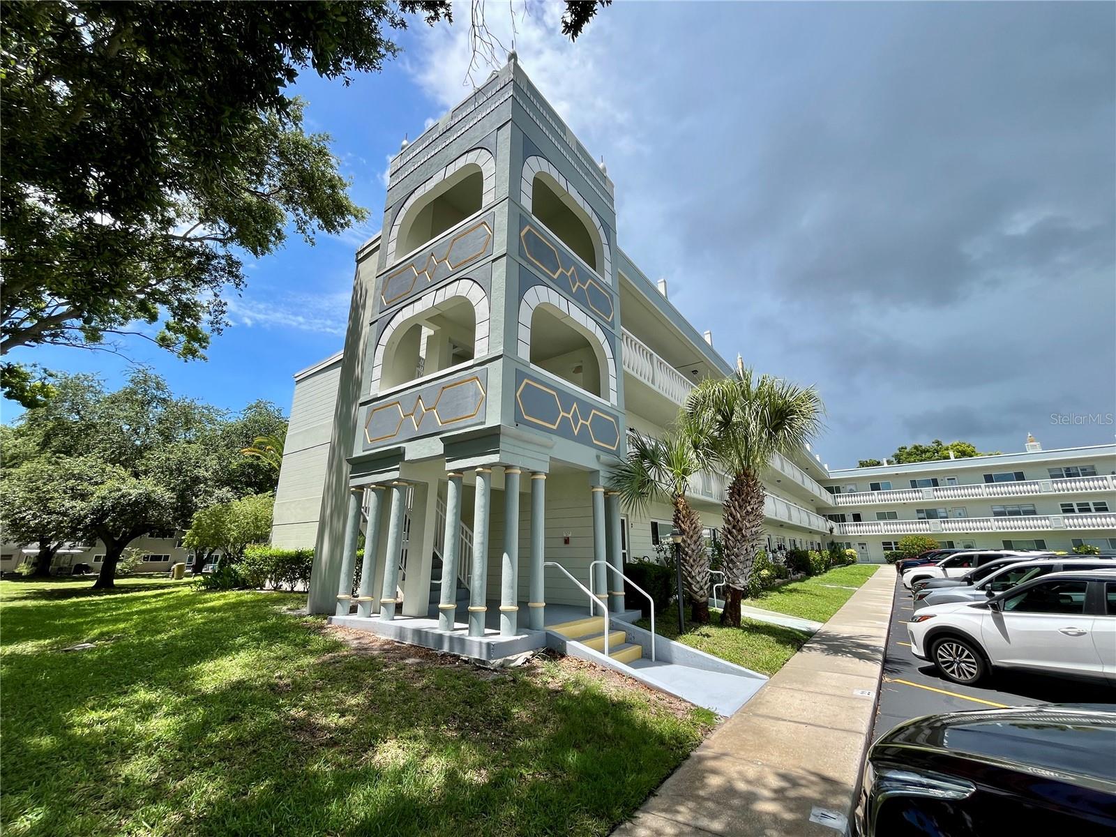 End Unit! Come see this 1400 sq ft furnished Emerald on the west side over looking the pool of west activity center and next to Arbor Lake. You are just steps away from a wealth of amenities including a heated swimming pool, jacuzzi, computer center and billiard room complete with 10 pool tables.  Enjoy the sunlight from the extra updated hurricane impact windows an end unit provides. A/C was replaced in 2026. This furnished open plan condo has it all. Assigned parking. The 55+ community has two activity centers, and two private golf courses with 9 and 18 holes, free exclusively for residents & owners. There are two heated swimming pools. The remodeled Cardio Gym has the latest exercise equipment. A very pet-friendly community, there is a fenced dog park with covered seating. There are hobby studios, and a wood shop for the exclusive use of the residents. Activities include fitness classes, dancing, clubs, cards, billiards, entertainment, classes, and much more. The on-site Good Karma Café has take & bake meals and snacks. Close to beaches, transportation, shopping, entertainment, and fine dining. All room sizes, floor plans and square footage are approximate. This property is being transferred by a leasehold estate deed. Association approval is required. If financing, a 35% down payment is required. Washer, dryer & hook ups must be approved by the association.