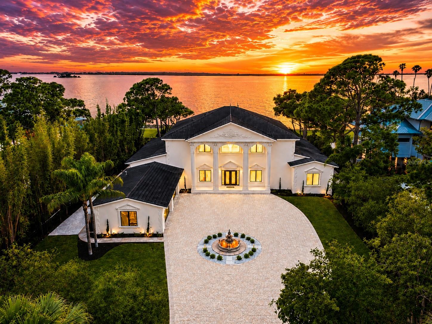 MASTERFULLY REIMAGINED, THIS EXTRAORDINARY WATERFRONT ESTATE IS SET ON A SPECTACULAR 1.1-ACRE LOT OVERLOOKING THE INTRACOASTAL WATERWAY AND THE PRISTINE SHORES OF CALADESI ISLAND. Originally built in 2002 and extensively upgraded in 2026. Constructed with enduring quality and resilience, the residence features insulated concrete form (ICF) walls, rebar-reinforced hurricane-impact windows/doors, and a roof fortified by metal trusses—delivering exceptional structural integrity and peace of mind. Beyond the impressive gated entrance, a sweeping shellstone driveway and meticulously curated landscaping introduce a home of remarkable elegance and distinction. Inspired by Coastal Tuscan architecture, stately pillars frame a grand foyer with soaring 24-foot ceilings, creating a dramatic first impression. Exquisite porcelain flooring, artisan-crafted millwork, graceful archways, fluted columns, contemporary designer lighting, and smooth Level 5 walls combine to create a sophisticated and timeless aesthetic. The expansive waterfront living room flows seamlessly into a refined formal dining area, offering an ideal setting for entertaining. At the heart of the home, the chef’s kitchen is truly exceptional, showcasing dramatic double-slab translucent quartzite countertops with ogee-edge detailing, matching quartzite backsplash, custom raised-panel cabinetry with under-cabinet lighting, premium appliances, gas cooking, built-in refrigeration, and dual islands with bar seating—all opening effortlessly to the pool deck and waterfront beyond. The spacious family room enjoys sweeping water views and features a custom multi-level entertainment bar and serving center with Sub-Zero refrigeration and a dedicated ice maker. The executive office, also positioned to capture the stunning waterfront setting, is appointed with extensive custom built-ins and offers generous space for workstations and conference-style seating. The luxurious owner’s suite is a private waterfront sanctuary, featuring a spacious sitting area and two beautifully designed custom closet systems. The spa-inspired owner's bath is a showpiece of craftsmanship and luxury, finished in marble, quartzite, and translucent quartzite. Highlights include dual vanities, a dedicated cosmetics center, sauna, private rest room, freestanding microjet soaking tub, and a spectacular dual-entry walk-in rain shower with five additional body sprays, all enveloped in rich marble finishes. Each of the four guest suites offers exceptional scale and comfort, complete with walk-in closet systems and beautifully appointed en-suite baths finished extensively in marble. Outdoors, the estate evokes the glamour and grandeur of a private waterfront resort. A dazzling 5,000-square-foot elevated shellstone deck with elegant diamond-pattern design surrounds the pool/spa and is enclosed by custom cast-stone balustrades. Your terraced lounging areas descend to a beautifully landscaped waterfront lawn reminiscent of an Italian villa. Enjoy the rare luxury of a private white-sand beach and a composite dock equipped with a 16,000-pound boat lift. Setup provides quick and convenient access to Clearwater Beach, Caladesi Island, and Honeymoon Island, offering an unparalleled combination of waterfront recreation and beachside enjoyment. Brilliant sunsets, refreshing coastal breezes, and an unmatched setting complete this truly one-of-a-kind coastal offering—conveniently located within easy reach of downtown Clearwater.