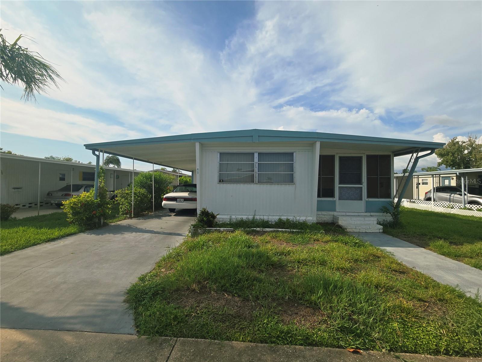 Great opportunity to own an affordable home located in the highly sought-after Tarpon Shores 55+ community. The $40,000 land share price is included in the list price and may be financed through the HOA. This 2-bedroom, 1-bath home is being sold As-Is and offers plenty of potential to update and make it your own. Major improvements include a new TPO Roof-Over (2023) and the seller believes the water heater was replaced in 2017. The central HVAC system (2009) is currently not operational. The spacious living room features newer laminate flooring, and the large Florida room provides additional living space to relax or entertain. The kitchen includes all appliances.  The washer and dryer are conveniently located in the storage shed and are in working condition. The primary bedroom offers built-in closets, while the bathroom features a walk-in shower with no tub and a single vanity with a tile countertop. There is plywood subflooring throughout most of the home except for the bathroom, offering a solid foundation for future flooring updates.  It does need a new vapor Barrier. Most furnishings will convey with the sale, with the exception of a portable air conditioner and some of the sellers personal items. Whether you're looking for a winter retreat, investment opportunity, or affordable year-round home, this property is ready for your personal touch.  *The list price includes the manufactured home and the $40,000 co-op ownership share (land interest). The share is part of the purchase price and is not an additional cost.*TARPON SHORES is known for its friendly atmosphere, organized activities, and resort-style amenities including a large clubhouse, Large heated pool, pickle ball, bocce ball, shuffleboard, billiards, BBQ area, library, and monthly newsletters. **The low monthly fee of $326 covers lawn care, lawn spraying, water, sewer, trash, cable TV, community info channel, and internet.** With low taxes and a fantastic location, you will enjoy the World-Famous Tarpon Springs Sponge Docks, beaches, parks, dining, shopping, boating, golf, and more, this beautifully updated home offers an easy, low-maintenance Florida lifestyle in a welcoming resident-owned community.