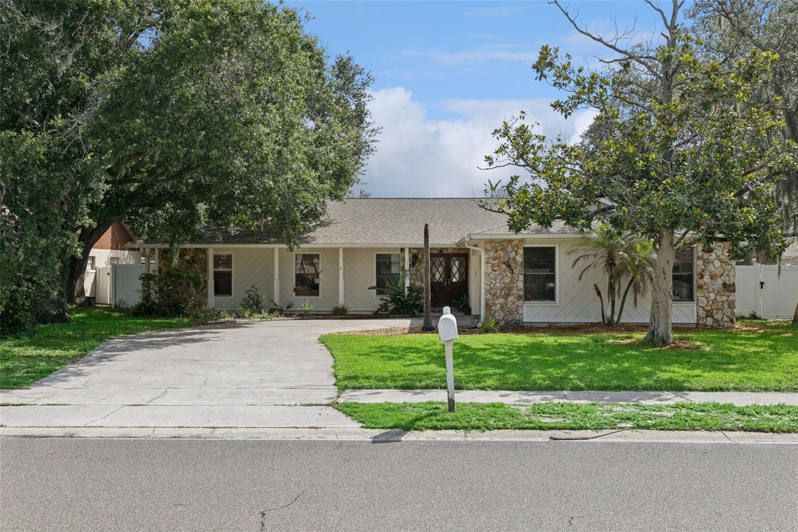 Welcome to this breathtaking home nestled under the canopy of mature oak trees in one of the area's most sought-after neighborhoods. Coach Light Estates of Fern Park checks all the boxes! This well established home is centrally located but, is still in a hard to find, old Florida neighborhood. This single-story masterpiece blends well thought out spaces sitting on .27 acre lot, with natural light throughout — ready for immediate move-in. Bonus* there are two additional buildings for storage or fun outside! The larger of these even has ac!

The striking facade features a combination of stacked stone, slanted wood panels, beneath a sleek roofline. A dramatic entryway door, 2-car garage, and lush green lawn with newly laid sod, framed by beautifully aged oaks give this home incredible presence and charm. Step through the stunning glass panel front door into a bright, airy foyer that flows seamlessly into the home.
Beautifully Updated Kitchen
The showstopping freshly updated kitchen features quartz countertops and seating for four, white shaker cabinetry, a stainless steel double sink and stainless steel appliances. Glass panel french-doors open directly to the backyard and pool — perfect for entertaining.
Living Areas. Open-concept living and dining areas are bathed in natural light with clean bright neutral walls, recessed lighting, and ceiling fans making this are a comfortable practical gathering space. The space is fresh, bright, and move-in ready. All three bedrooms feature engineered hardwood flooring, generous closet space. The bedrooms are spacious and filled with natural light. The inspired bathrooms feature tile flooring. A wrap-around shower in the primary bedroom completes the luxurious feel. A dedicated laundry room comes equipped with a washer and dryer, and plenty of storage space right next to the garage.  
Outside Oasis 
The fully fenced backyard features a glorious pool with brick paver surround, sun shelf and fountain water feature. The removal fence is also available to ensure safety. Plenty of privacy and relaxation to be had by all (including furry family members.) Steps away from the pool is a wonderful green space for gardening or other outdoor pursuits. The additional building also has easy access to the pool allowing you to jump right in after working or working out.  
Additional Features
2-car attached garage
newer roof (2022)
Within walking distance of Kewannee Trail 
Fresh landscaping with newly planted sod