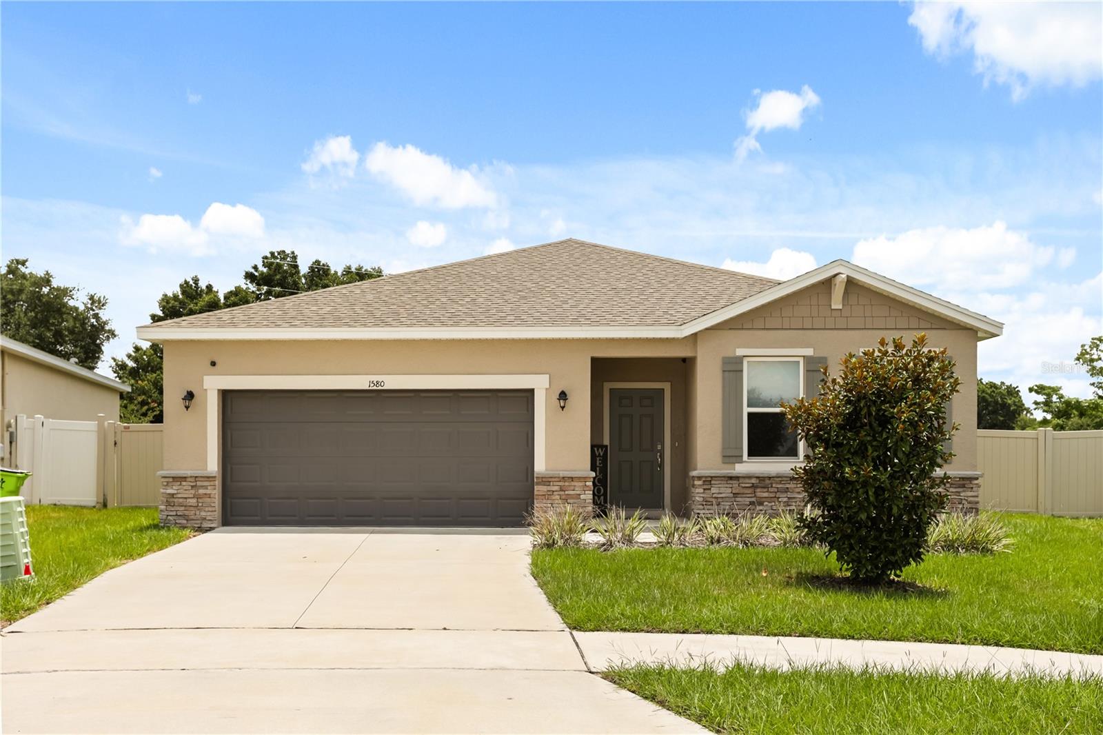 Better than new and priced to sell! Skip the construction delays and step into this beautifully maintained 2023 home in Sunset Lakes, where modern design, flexible living spaces, and a growing Lake County location come together to create an exceptional opportunity. Why wait months for new construction when you can move right into this beautifully maintained 2023-built home offering 4 bedrooms, 3 full bathrooms, and over 2,200 square feet of thoughtfully designed living space? Whether you're searching for your forever home, need space for a growing family, or simply love an open floor plan with room to entertain, this home checks all the boxes. Step inside and you'll immediately appreciate the bright, open layout where the kitchen, dining, and living areas flow seamlessly together, creating the perfect gathering space for everything from holiday celebrations to casual movie nights. The well-appointed kitchen features abundant cabinetry, generous counter space, a pantry, breakfast bar, and plenty of room for the chef to stay connected with family and guests. One of this home's standout features is its two private primary suites, making it ideal for multigenerational living, long-term guests, or even a luxurious home office setup. The split-bedroom floor plan provides flexibility while maintaining privacy for everyone. The spacious primary suite offers a relaxing retreat complete with a large walk-in closet and ensuite bath. Additional bedrooms are generously sized and share access to well-appointed bathrooms, making everyday living comfortable for everyone. Outside, enjoy your covered lanai overlooking the fully fenced backyard—a perfect space for weekend cookouts, pets, gardening, or simply relaxing with your morning coffee while planning absolutely nothing productive (because you've earned it). Additional upgrades include a water softener, epoxy-coated garage floor, indoor laundry room, and an attached two-car garage. Located in the desirable Sunset Lakes community, residents enjoy sidewalks, attractive streetscapes, and a welcoming neighborhood atmosphere with a low HOA. The location offers the best of both worlds—peaceful suburban living while remaining just minutes from shopping, dining, schools, parks, Lake County's growing trail system, Clermont, and convenient access to State Road 50, the Florida Turnpike, Orlando, Disney, and Central Florida's major employers. Mascotte continues to grow as buyers discover its affordability, newer communities, and convenient location without sacrificing the relaxed Florida lifestyle. This home is truly move-in ready—the only thing missing is you.