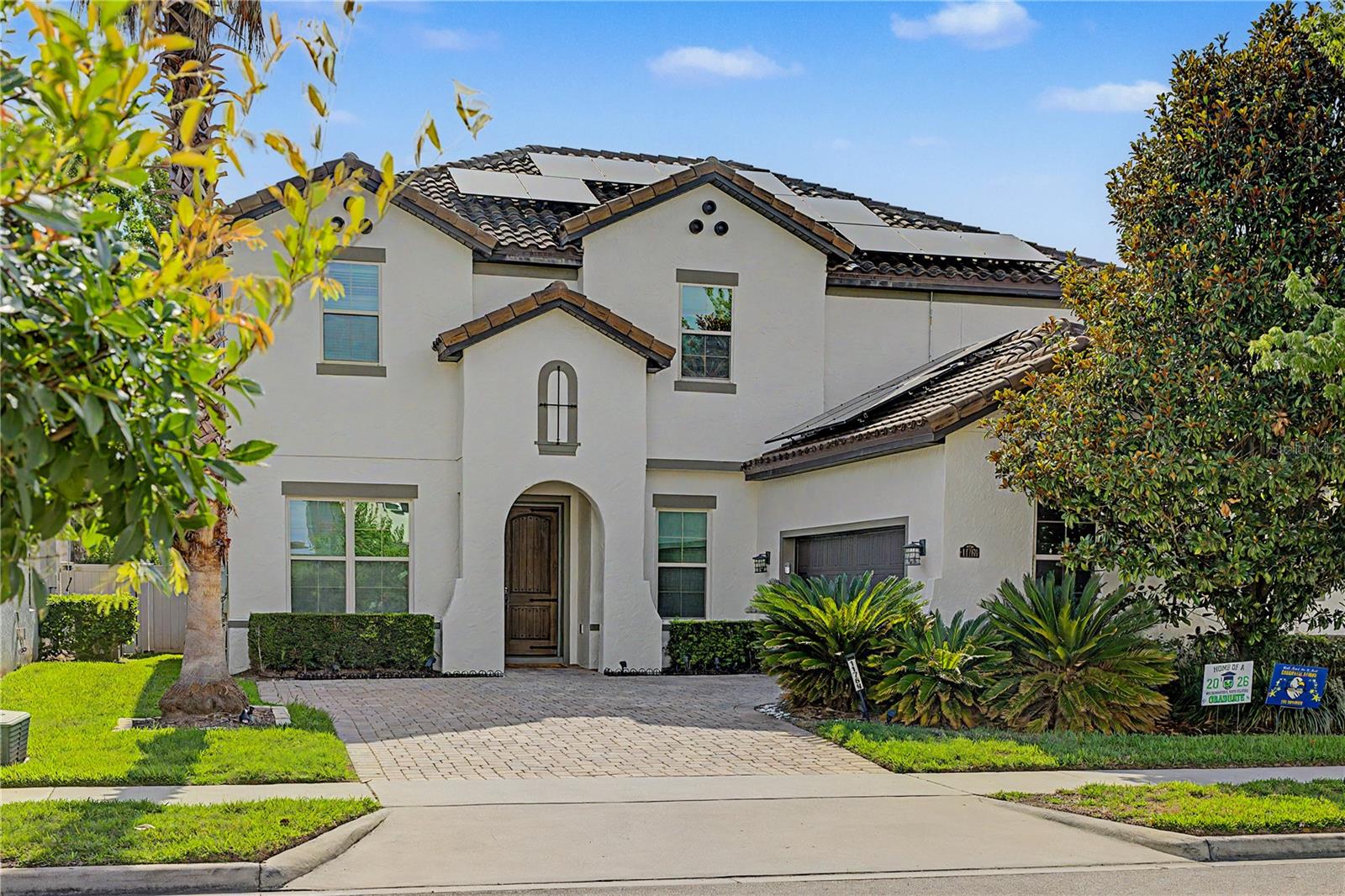 One or more photo(s) has been virtually staged. Nestled within the prestigious Enclave at Windermere, this stunning Mediterranean-style residence delivers the Florida luxury lifestyle in every detail — from the moment you step through the rustic wooden front door.

Soaring 10-foot ceilings and large-format 24x24 white and grey-veined porcelain tile set the tone for the main level. To the right, French panel doors open to a private home office. To the left, a formal dining room anchored by a grand crystal chandelier flows seamlessly into a butler's pantry outfitted with 42" espresso cabinetry, white granite countertops, and a generous walk-in pantry.

The gourmet kitchen is designed for those who take both cooking and entertaining seriously — featuring stainless steel Whirlpool appliances including double ovens, a glass cooktop with a vented stainless hood, built-in microwave, and a Samsung French door refrigerator. Espresso cabinetry is beautifully contrasted by dark grey subway tile and white granite counters, while the oversized island with dual under-counter sinks and a modern Moen faucet doubles as an additional gathering space.

The open-concept layout connects the kitchen and breakfast area to the great room, where natural light pours in through double-paned windows, sliding glass doors, and two sets of French doors — all leading to an expansive paver pool deck, ideal for entertaining. A custom accent wall adds warmth to the living area, which also provides access to two carpeted bedrooms and a full bath on the main floor. Thoughtful storage is tucked beneath the staircase, and the two-car garage — complete with epoxy flooring and a laundry sink — opens to a practical mudroom with ample upper and lower cabinetry.

Upstairs, a generous loft area creates a natural transition to the private quarters. The primary suite features a tray ceiling and a spa-inspired bath with dual vanities, white granite counters, espresso cabinetry, porcelain tile flooring, a garden soaking tub, and a large walk-in tiled shower. The walk-in closet has been fully customized with a California Closet system. A third bedroom offers en suite privacy with its own walk-in shower. Bedrooms four and five share a well-appointed hallway bath with dual sinks and a tub/shower combination. The upstairs laundry room is equally refined — front-loading washer and dryer on pedestals, a secondary sink, and tile backsplash.

Outside, the fully fenced paver deck with a large covered lanai and a modern pool creates the perfect backdrop for Florida living. This is not just a home. It is a lifestyle!