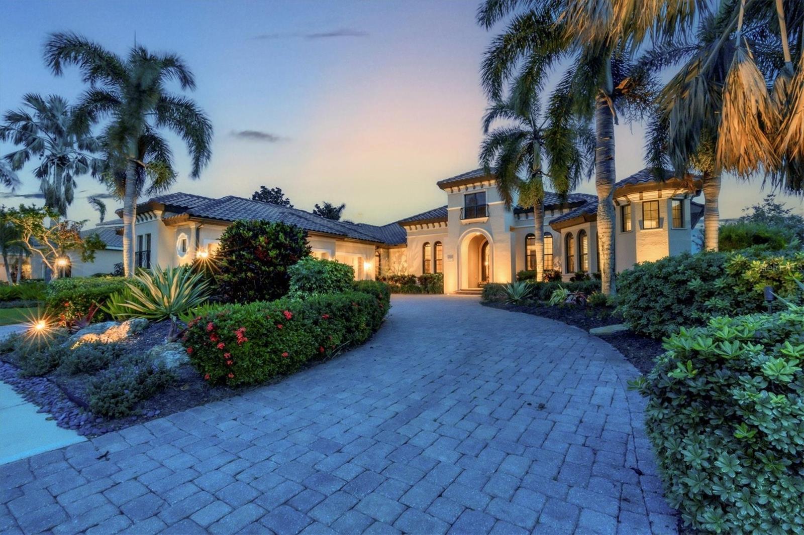 Welcome to this exquisite custom home, perfectly situated on one of the finest lots in Country Club East, offering breathtaking lake and golf course views. Designed with sophistication and functionality in mind, this residence welcomes you with an open foyer, soaring ceilings, spacious rooms, a warm color palette, and meticulous attention to detail throughout. The thoughtfully designed floor plan creates a seamless flow through expansive living and dining areas, leading to a chef's kitchen complete with wood cabinetry, granite countertops, a large island, hidden walk-in-pantry, high-end appliances, and a cozy breakfast nook. The elegant living room features a gas fireplace, rustic wood beam ceiling accents, and a stunning wall of glass that floods the space with natural light and showcases the serene views. Adjacent, the dining room offers ample space for large gatherings, while the family room opens effortlessly to the kitchen and invites outdoor living with corner pocket sliding glass doors leading to the lanai. Beyond the family room, discover a versatile bonus room with a wet bar and beverage refrigerator-perfect for a second office, home gym, or game room. The primary suite is a private oasis, boasting a dedicated foyer, a relaxing sitting area, dual walk-in closets, two water closets, double vanities, a jetted tub and a spacious walk-in shower. The family room, bonus room, and primary suite each open directly onto the expansive lanai and pool area, designed for ultimate relaxation and enertaining, with multiple covered and uncovered seating areas, a complete outdoor kitchen, fireplace, and a heated pool and spa. Completing this exceptional home are three additional bedrooms, three and a half bathrooms, a dedicated office, and a generous laundry room. Residents of Country Club East enjoy a host of amenities, from a state-of-the-art gym, spinning classes, tennis, pickleball, and basketball courts to community pools-all included in the HOA. Located near The Mall at Univeristy Town Center, dining, shopping, and Lakewood Ranch Country Club's premier golf courses, this home offers an unparalleled lifestyle of luxury and convenience.