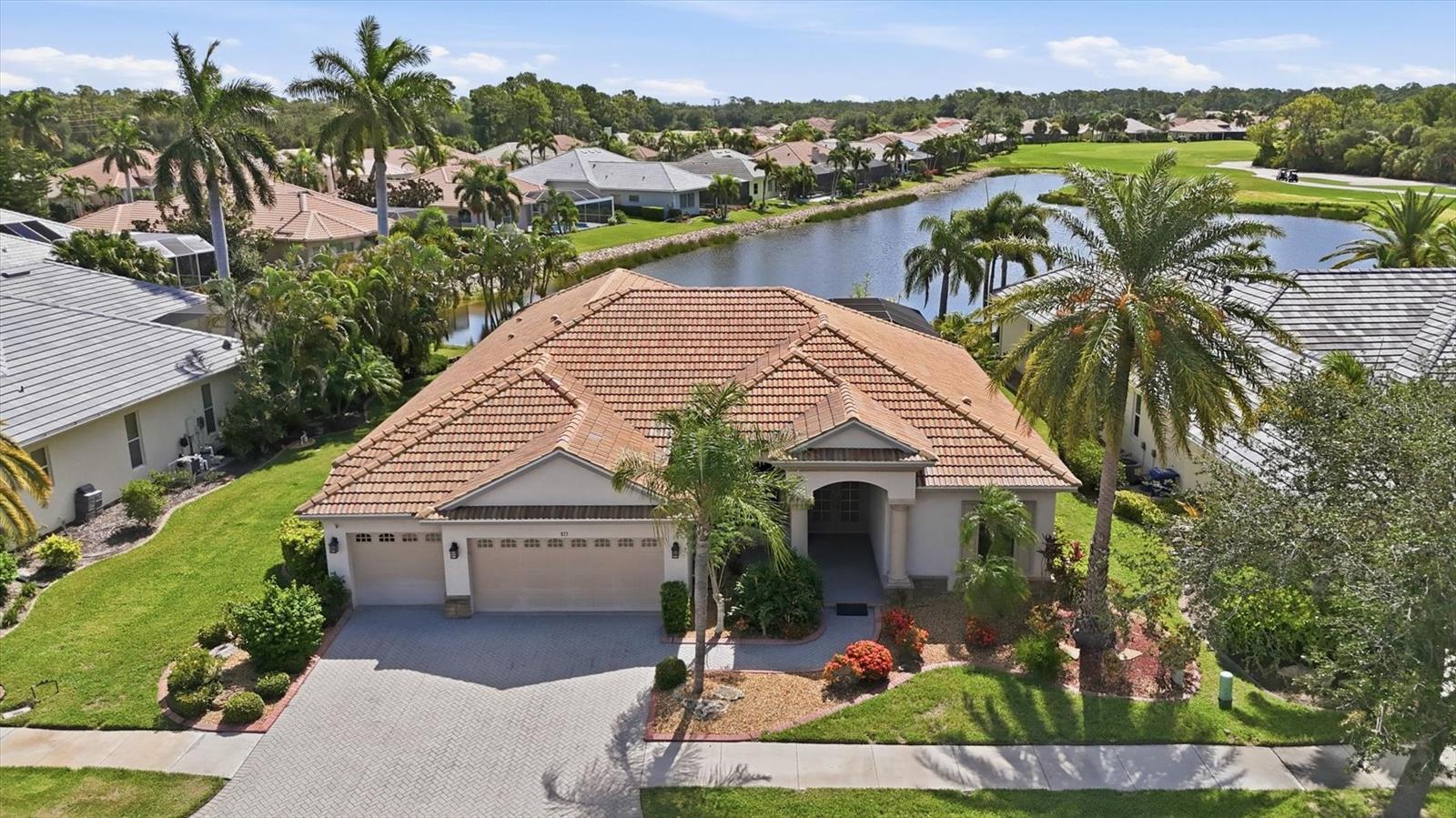 Experience refined Florida living in this elegant executive residence, ideally situated on a quiet cul-de-sac within the prestigious, gated community of Pelican Pointe Golf & Country Club. Positioned on an oversized homesite with desirable eastern rear exposure, this exceptional home captures breathtaking sunrise views across the lake and the 26th hole of the championship golf course, creating a private and serene backdrop.

Designed to embrace the Florida lifestyle, the expansive great room features dramatic sliding window walls that completely open to the lanai, creating a seamless transition between indoor and outdoor living. The screened, resort-style pool area is an entertainer's dream, highlighted by a newly added poolside outdoor kitchen, sparkling caged pool, and generous covered lanai where family and friends can gather while enjoying tranquil golf and water views.

At the heart of the home, the gourmet kitchen showcases custom wood cabinetry, Corian countertops, stainless steel appliances, an oversized center island, and a bright breakfast area framed by stunning floor-to-ceiling aquarium windows overlooking the pool and fairway.

The thoughtfully designed split floor plan offers exceptional privacy. The luxurious primary suite is a peaceful retreat featuring two spacious walk-in closets, dual vanities with an extended countertop, a relaxing jetted soaking tub, and a walk-in Roman shower. Two additional guest bedrooms and baths are thoughtfully positioned on the opposite side of the home, providing comfort and privacy for family and visitors, while a private den offers the perfect space for a home office, library, or media room.

Throughout the home, quality craftsmanship is evident in the soaring ceilings with double tray details, crown molding, formal living and dining rooms, integrated speaker system, smart home technology, central vacuum system, hurricane protection, custom audio/visual cabinetry, abundant storage, a spacious laundry room, and an oversized three-car garage with a paver driveway. Additional upgrades include dual air conditioning systems for enhanced comfort and efficiency, as well as a Flo by Moen® Smart Water Monitor and automatic shutoff system that provides advanced leak detection and water protection directly from your smartphone.

Pelican Pointe offers an exceptional resort-style lifestyle with an impressive clubhouse, restaurant and bar, heated community pool, fitness center, tennis and pickleball courts, and an active calendar of social events. Optional golf membership provides access to the community's award-winning 27-hole championship course. Located just minutes from Venice's pristine Gulf beaches, charming downtown, waterfront dining, boutique shopping, and spectacular sunset walks along the jetty, this remarkable home offers luxury, comfort, and the very best of Florida living.