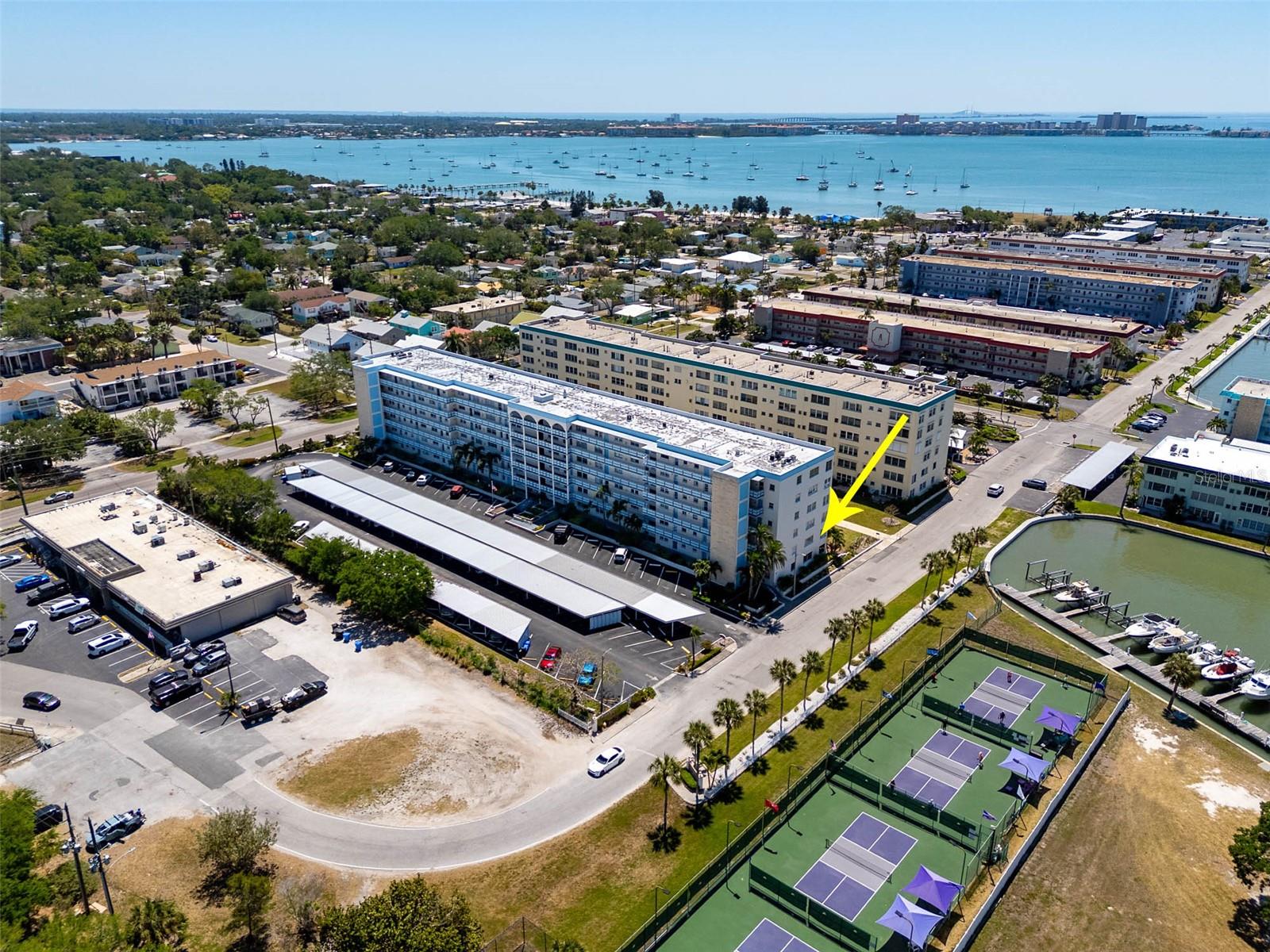 Spacious corner condo with 2 bedrooms - 2 bathrooms - 1250 heated square feet of living space. Tons of natural light shining through the bank of windows providing views of the intercoastal canal and marina. The unit boasts a generous-sized primary bedroom with walk-in closet and en suite bathroom, galley kitchen with tons of cabinet space and a gas stove, a second bedroom and bathroom for guests, open and bright  floor plan with a living room/dining room combo that's perfect for entertaining family and friends, an assigned covered carport space, A/C replaced in 2023 and community laundry room located on the same floor. Located in the Kenmore Building, it is situated next to 1 of 4 community pools. Town Shores of Gulfport is a vibrant 55+ condo community offering Florida living at its best with fantastic community amenities. Enjoy the community clubhouse, fitness center, billiards, shuffle board, tennis courts, 4 pools and kayak/paddleboard storage. The heart of downtown Gulfport is just a couple of blocks away offering restaurants, pubs, coffee shops, Gulfport Beach, parks, the library, Gulfport Casino, boardwalk and much more! This lovely condo won't last long! Schedule your private showing today!