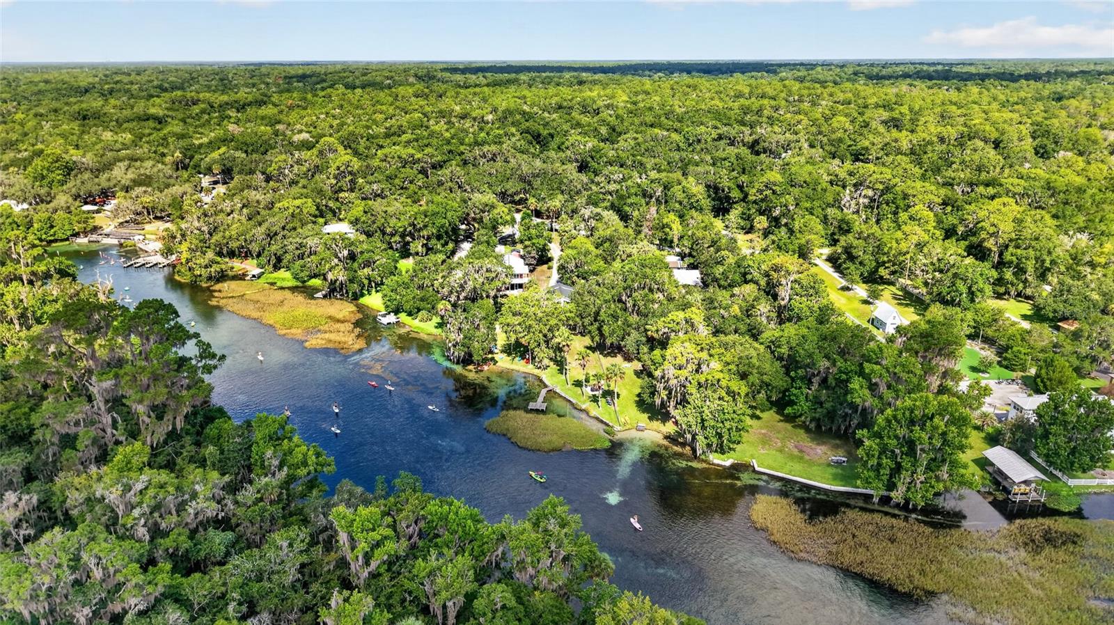 Welcome to one of the Rainbow River’s most desired locations, just north of KP Hole Park, where the water settles into that unmistakable turquoise the river was named for. Across the bank, preserved in perpetuity, protected state park land rises in a skyline of cypress, mirrored on the water’s surface — a view of beauty you’ll never tire of looking at. Full of love and appreciation for its beauty, this 2/2.5/2 gated riverfront home has been thoughtfully updated, adding a rare touch of luxury and ease to life along the Rainbow River. Move-in ready and gorgeously renovated, this is the kind of place where you truly don’t have to lift a finger — settle in. Inside, the kitchen has granite countertops and upgraded appliances, opening to a bar view overlooking a beautiful view of the Rainbow River. Two spacious bedrooms, with a gorgeous recently remodeled primary bathroom, and a sleeping loft — with its own river view — bring an unexpected romantic twist, begging to become someone’s favorite reading nook or private hideaway. The fireplace adds that extra layer of warmth, drawing you closer as you unwind after a day of playing on the river. But the back porch may be where you end up living most of the year. And in all reality, coffee just tastes different here — sip slowly and watch the morning mist rise off the water as the river drifts by in its own unhurried time. With a new roof in 2024 and new HVAC arriving in the coming weeks, the big-ticket items are already taken care of — so all that’s left to do is relax and enjoy life. Best of all, step outside to your dock and quietly slip into your private swimming area - 72-degree spring water, cool and clear even on the warmest Florida afternoon. Watch Great Blue Herons stand motionless in hunting position along the shoreline, Ospreys wheeling overhead before folding into a dive, and turtles working their funny, almost yoga-like contortions as they perch on nearby logs. If you’re lucky, a few otters might slip past, playing in the shallows. Some homes give you a view.  This one gives you a relationship — with the water, with the wildlife, with a stretch of river so protected and so pristine that its beauty is written into law as much as it is into the landscape. Here, morning comes with company you didn’t have to invite.