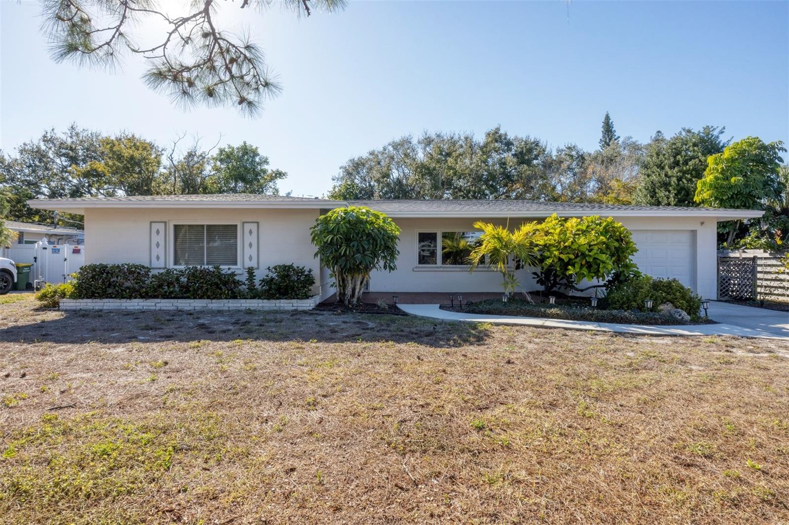 ENJOY THE BEST OF FLORIDA LIVING in this beautifully maintained mid-century modern home. Featuring 4 bedrooms, 2 1/2 bathrooms, an extended 1 car garage and over 2000 square feet of thoughtfully designed living space. This open floor plan offers a desirable split floor plan with two en-suite bedrooms, an updated kitchen, and large family room perfect for everyday living or entertaining. For additional peace of mind there is a NEW ROOF and IMPACT WINDOWS. Step outside on your lanai where you can create your outdoor oasis or enjoy the views of the oversized backyard. Located in Sapphire Shores, this home is minutes to University Town Center, SRQ airport, Ringling Museum, Downtown Sarasota, St. Armand’s Circle, Lido Beach and offers two bay front parks providing access for water activities and views. A perfect blend of comfort, space and location – this home truly delivers a lifestyle like no other.