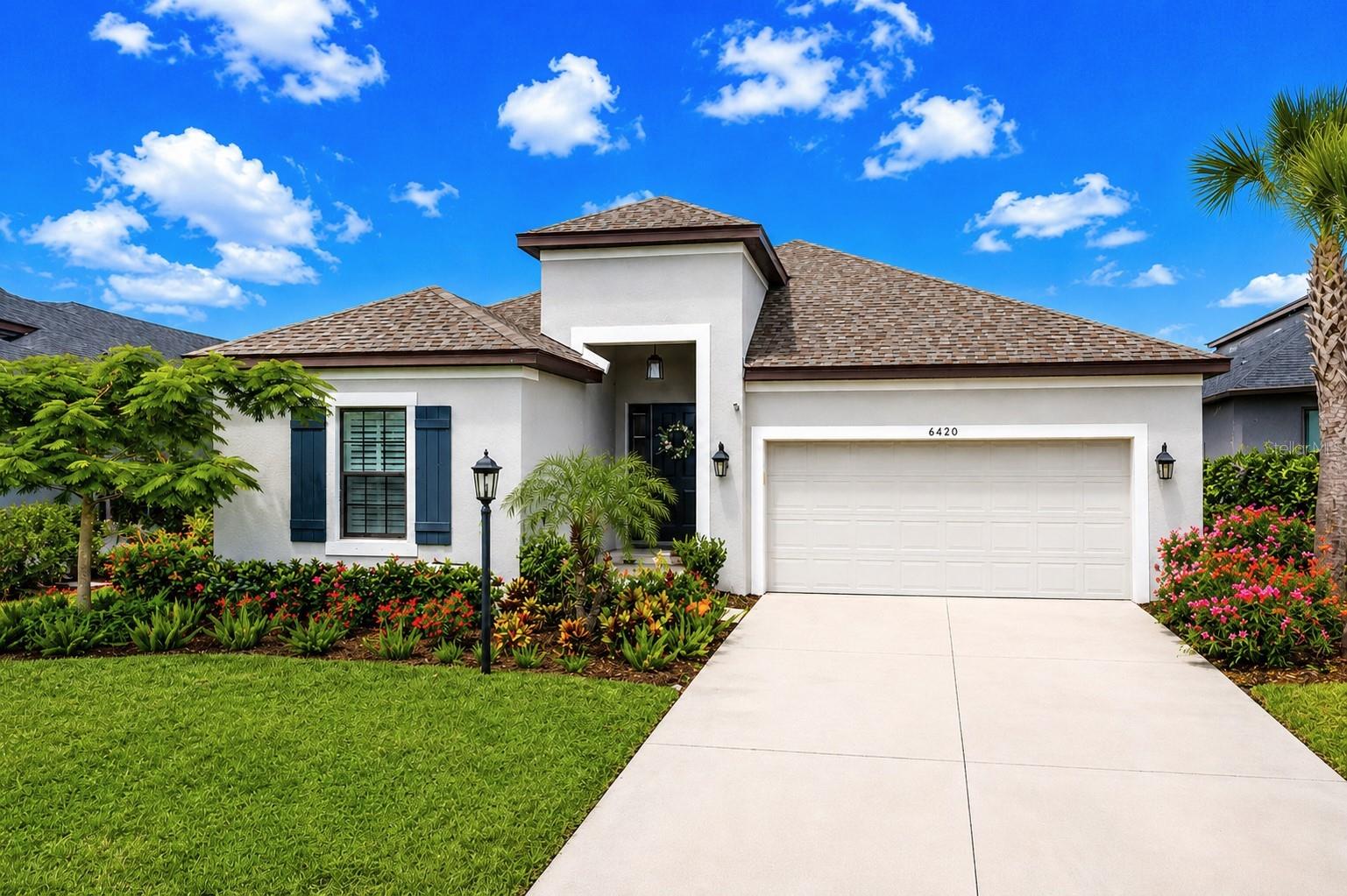 GRANDVIEW AT THE HEIGHTS STUNNER! From the moment you step inside this gorgeous home that shows like a model you will encounter the upgraded finishes and experience the open and luxuriously designed ultra-light & bright piece of art. This showpiece is ideal for effortless entertaining, featuring an extended picture window lanai with over 600sqft of outdoor living space finished with paver flooring and panoramic lake views that spotlight sparkling sun sets across the water. The lanai also has 2 accented Alaska gray marble walls & the backyard is fenced in for your precious pet. The heart of this home is an impressive open-concept great room, thoughtfully designed while a separate formal dining room and bar area provide additional space for entertaining.  Enjoy living in this exceptional home that features: *Porcelain plank tile flooring *Elegant crown molding, plantation shutters, designer lighting and remote control ceiling fans *The gourmet kitchen features white shaker cabinets with slam free doors and are completed with crown molding *Moen kitchen faucet with pull out sprayer and garbage disposal *Premium Silestone countertops made in Spain by Cosentino *8 by 4 foot island with a stainless steel farmhouse sink *Stainless steel appliances and gas range that vents to the outside *The spacious primary suite offers tranquil lake views and features an impressive 13' x 8' walk-in closet complete with custom built-in shelving *Laundry room features LG washer & gas LG sensor dry dryer with direct access from the primary closet *The luxurious primary bath features dual Corian topped vanities, polished chrome Moen faucets, beautifully tiled frameless glass shower with rainfall shower head and a soaking tub to relax away *Includes a tankless gas water heater, delivering endless hot water while maximizing energy efficiency *Inside the garage the home is generator-ready with a dedicated power inlet, allowing for backup power during outages, just plug in your generator and you're all set with power to the house. *Insulated garage door & includes hurricane shutters *The exterior is beautifully finished with freshly mulched landscaping, lush tropical plantings, and a stunning Royal Poinciana tree that has vibrant red blooms. After enjoying all the exceptional features this home offers, step outside and experience the unmatched lifestyle of this distinguished gated community. Enjoy access to a resort-style community pool featuring comfortable lounge seating, and picturesque surroundings, creating the perfect setting for relaxation. The community is home to the iconic Mount Tumulo, a one-of-a-kind landmark offering elevated walking trails, 4 fitness stations, 2 dog parks, breathtaking sunset views, and panoramic scenery rarely found in Southwest Florida. Outdoor enthusiasts will appreciate access to 2 community kayaks for exploring the 255-acre Lake Ward, which connects directly to Jiggs Landing, providing opportunities for fishing, wildlife viewing, and outdoor adventure. Additional amenities include a half basketball court, playground, and scenic walking paths, creating an active and engaging lifestyle. Ideally located in a popular area of Bradenton, offering convenient access to the mega popular UTC Mall, shopping and outstanding dining, Nathan Benderson Park, Sarasota-Bradenton International Airport, world-class Gulf Coast beaches and top-rated golf courses. Get the keys to unlock your happy home and start enjoying a Florida lifestyle today.