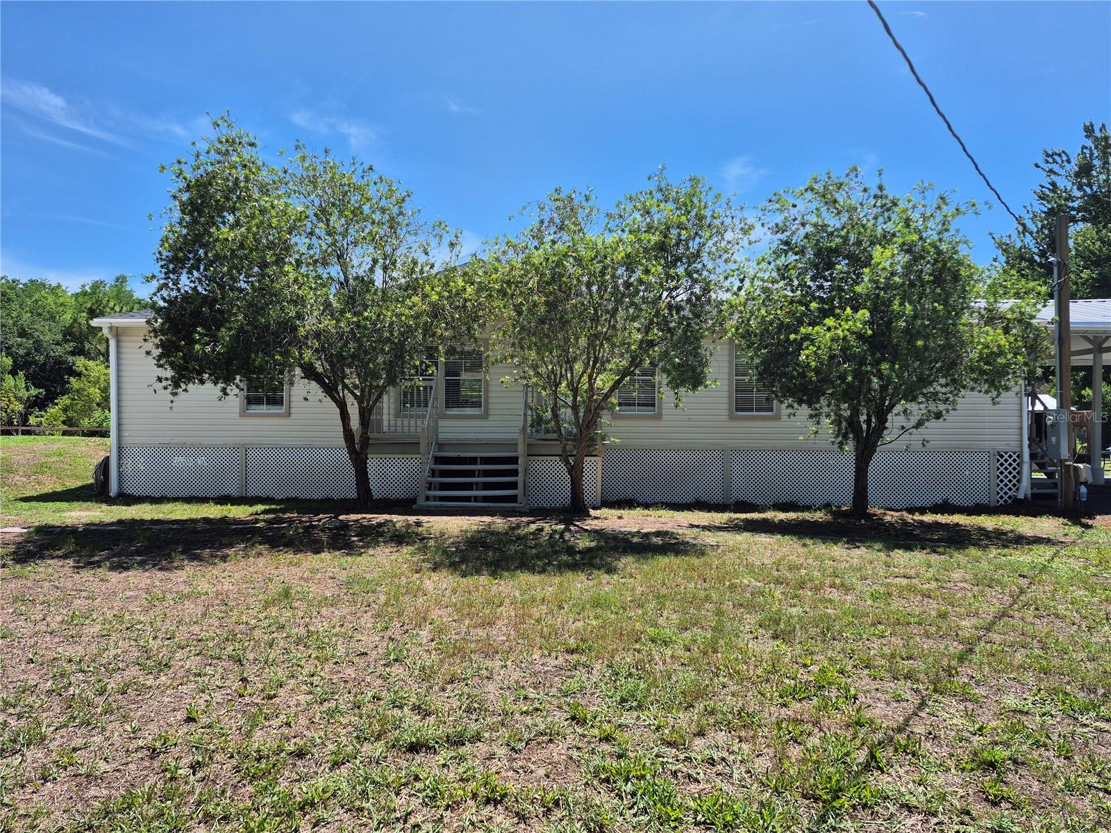 Under contract-accepting backup offers. Country life oasis with modern comfort! Move-in ready 3-bedroom, 2-bathroom DOUBLE WIDE HOME (2001 BUILD)  situated on 3.98 acres  - (nature preserve & sunset views) (No HOA rules!)
Escape the cookie cutter subdivisions and enjoy the freedom of the countryside! Located on a spacious 3.98-acre lot with AR (Agricultural-Residential) zoning, this beautifully refreshed 3-bedroom, 2-bathroom double-wide manufactured home offers the perfect blend of peaceful rural living and modern convenience. It is completely move-in ready and waiting for you!
MAJOR HIGH-VALUE UPGRADES
Enjoy total peace of mind for years to come! This home features a brand-new roof and a new AC (HVAC) system, offering maximum energy efficiency and a cool environment during warm Florida summers.
 SPECTACULAR INTERIOR 
Step into a bright and spacious split floor plan, designed for family living and entertaining. The entire home has been  revitalized with brand-new flooring throughout and a fresh coat of interior paint. The heart of the home seamlessly connects the common areas with a spacious layout that includes sparkling clean bathrooms, plus walk-in closets in every bedroom.
 THE ULTIMATE OUTDOOR PARADISE
The true gem of the property is the massive open back porch that runs the entire length of the house. Sip your morning coffee or afternoon iced tea while enjoying breathtaking, unobstructed views of your own natural preserve. This property is a sanctuary for local wildlife, where you can watch deer pass by and observe birds flying against the backdrop of Florida's famous, colorful sunsets.
READY FOR A HOBBY FARM & FREEDOM
Bring your RVs, animals, and trucks! With no HOA restrictions or fees, you have total freedom to live your way. The property features:

Large chicken coop: Ready to start your own farm-fresh egg project at home.
Vintage horse barn: An excellent foundation for horse lovers or additional rustic storage.
Extra Tall carport: Perfect protection for your RV, boat, tractor, or lifted trucks.
 PERFECT LOCATION
Enjoy the serenity and silence of a large country property without sacrificing convenience. It is located just minutes from major roads, giving you quick and easy access to local shops, restaurants, schools, and commuter routes.  TOUR THIS ONE TODAY, BEFORE IT GETS AWAY!