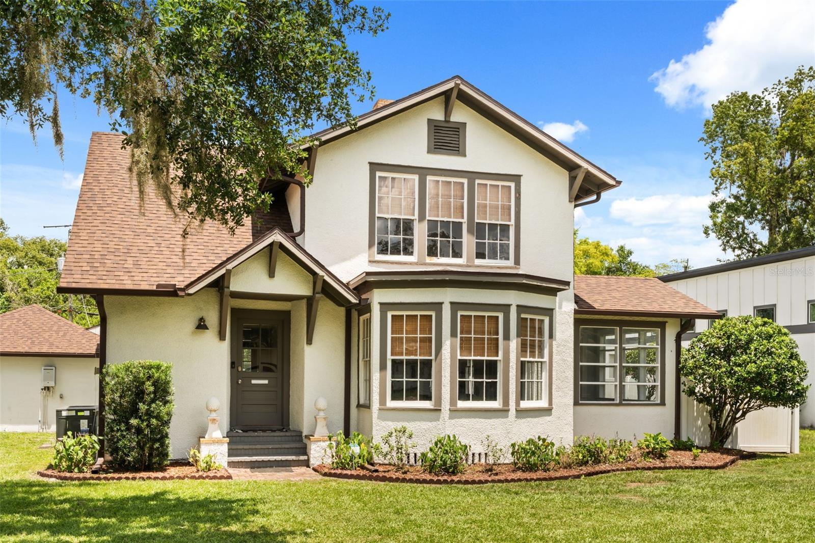 This 1920 Craftsman four-square in Sanford's Rose Court community was the childhood home of Donna Lou Harper Askew, First Lady of Florida, with her father's initials still carved in the back steps. That is the history. Here is the home. You are welcomed by a bright enclosed front porch surrounded by walls of windows, perfect as a sitting room, home office, or morning coffee spot. Inside, the formal living and dining rooms are flooded with natural light and showcase the original character throughout: restored oak hardwood floors, intact millwork and solid wood doors, a stained glass window, French door entryways, double-hung wood windows, and FOUR separate fireplaces. The fully renovated 2025 kitchen features shaker cabinetry, granite and butcher block counters, subway tile backsplash, black and white tile floors, farmhouse sink, gas range, and a Samsung Bespoke appliance suite, with an in-kitchen eating area and breakfast nook beside the formal dining room. Upstairs are three bedrooms, including the primary suite with walk-in closet and its own cozy fireplace, plus a renovated bathroom with custom tile work and a modern vanity. Adding exceptional versatility, the property also features a private living suite complete with its own entrance, kitchenette, full bath, and generous living area, ideal for multigenerational living, guests, a home office, or potential rental income. The oversized fenced yard includes an outdoor kitchen with gazebo and a workshop/golf cart garage, both with utilities, all in Sanford's Eastside golf cart zone minutes from Historic Downtown dining, Lake Monroe, and SunRail. Best of all, the home carries over $170,000 in documented improvements with every major system updated. The character is original. The worries are not. Schedule your private tour today.