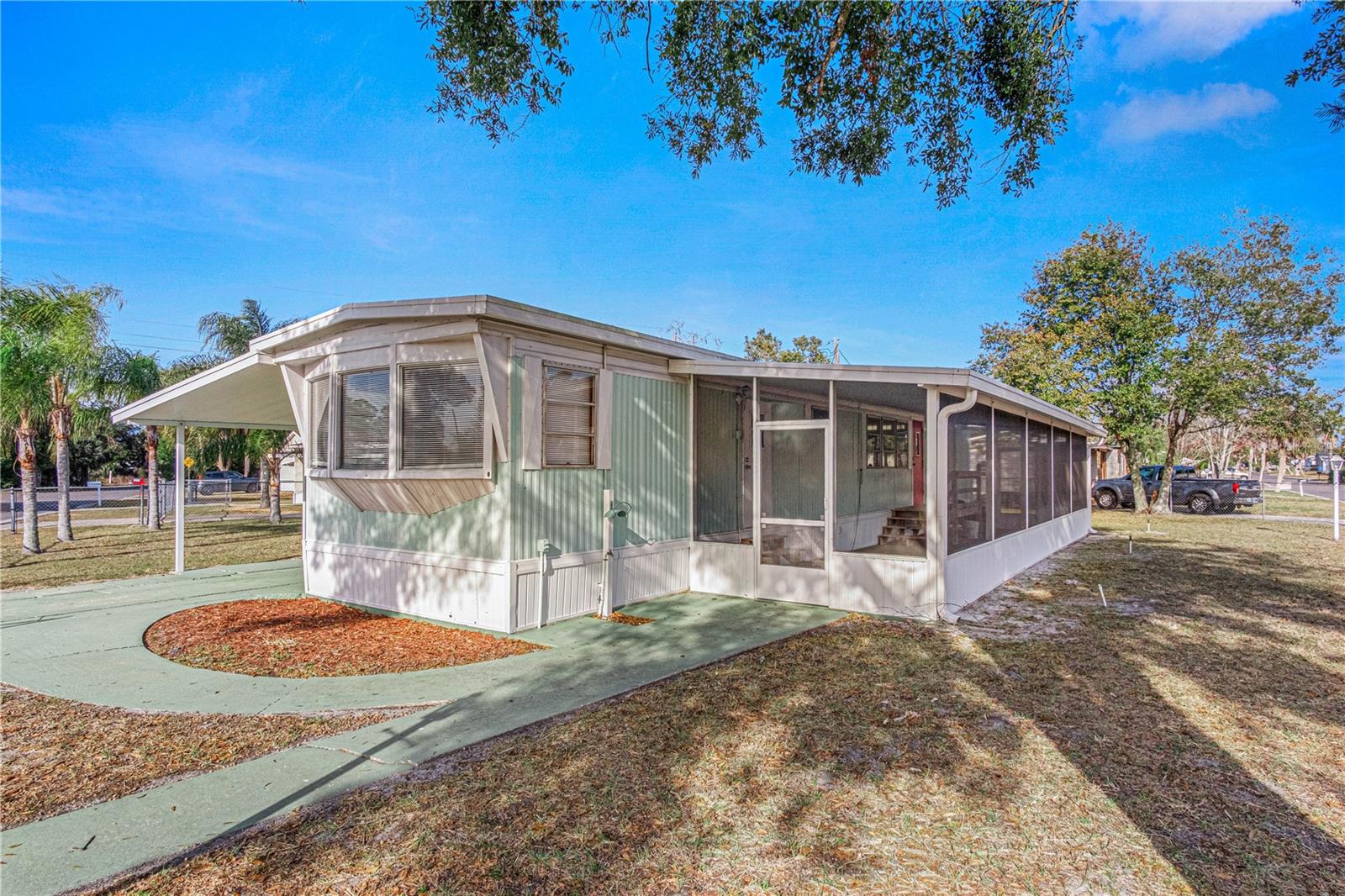 No HOA! You Own the Land! Private Financing Available! Enjoy affordable Florida living with the freedom of homeownership on this .17-acre fully fenced lot. This well-maintained 2-bedroom, 1-bath mobile home offers a functional floor plan and charming vintage character with classic paneled walls throughout. A long enclosed screened porch provides the perfect space to relax, entertain, enjoy morning coffee, or expand your living area year-round. Outside, the property truly shines with a long covered carport providing ample parking, a storage shed with laundry hookups, and two gated entrances for added convenience. One gate offers easy vehicle access, while the second provides plenty of room for a boat, trailer, RV, or other recreational toys. The spacious yard offers endless possibilities for pets, gardening, and outdoor enjoyment. A rare opportunity to own your land with no lot rent and no HOA restrictions. All information taken from tax records and deemed reliable but not guaranteed.