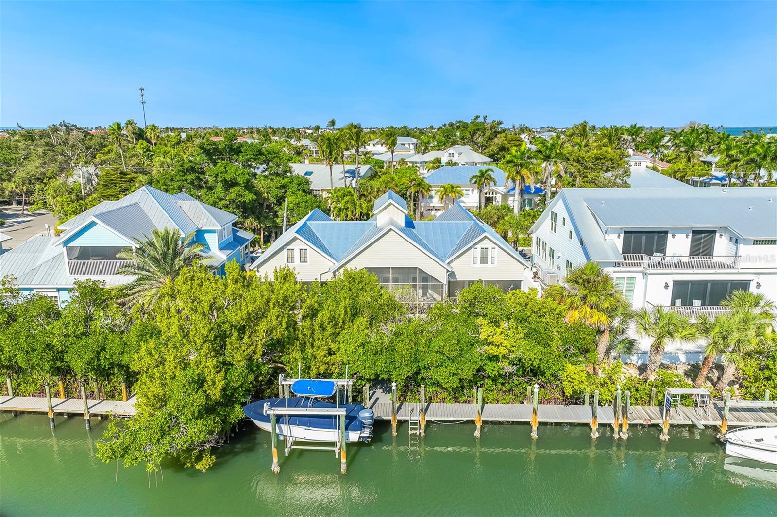 Custom-built by renowned McHugh Porter Builders and thoughtfully designed by historic preservation architect Henry Browne, this exceptional 4-bedroom, 4.5-bath waterfront residence blends timeless coastal architecture with modern comfort in the heart of Boca Grande’s historic district. Perfectly positioned on a no-bridge boating canal, the home offers direct water access and an effortless island lifestyle.

Inside, warm yellow pine floors, soaring cathedral ceilings with exposed beams, and abundant natural light create an inviting yet refined atmosphere. The open-concept kitchen flows seamlessly into spacious living and dining areas, while an expansive waterfront porch provides the ideal setting for entertaining or enjoying tranquil canal views. The first floor features a luxurious primary suite and private guest suite for convenient single-level living.

In 2011, the home was thoughtfully expanded to include two additional guest bedrooms and a generous loft-style family room with a full bath, offering flexible space for family and visitors alike. Exterior highlights include low-maintenance Xeriscape landscaping, durable Hardiplank siding, and a 2022 metal roof for lasting peace of mind.

Completing the property is a private dock with a 10,000-pound boat lift, making this an outstanding opportunity for boating enthusiasts seeking historic charm, quality craftsmanship, and exceptional waterfront living in Boca Grande.