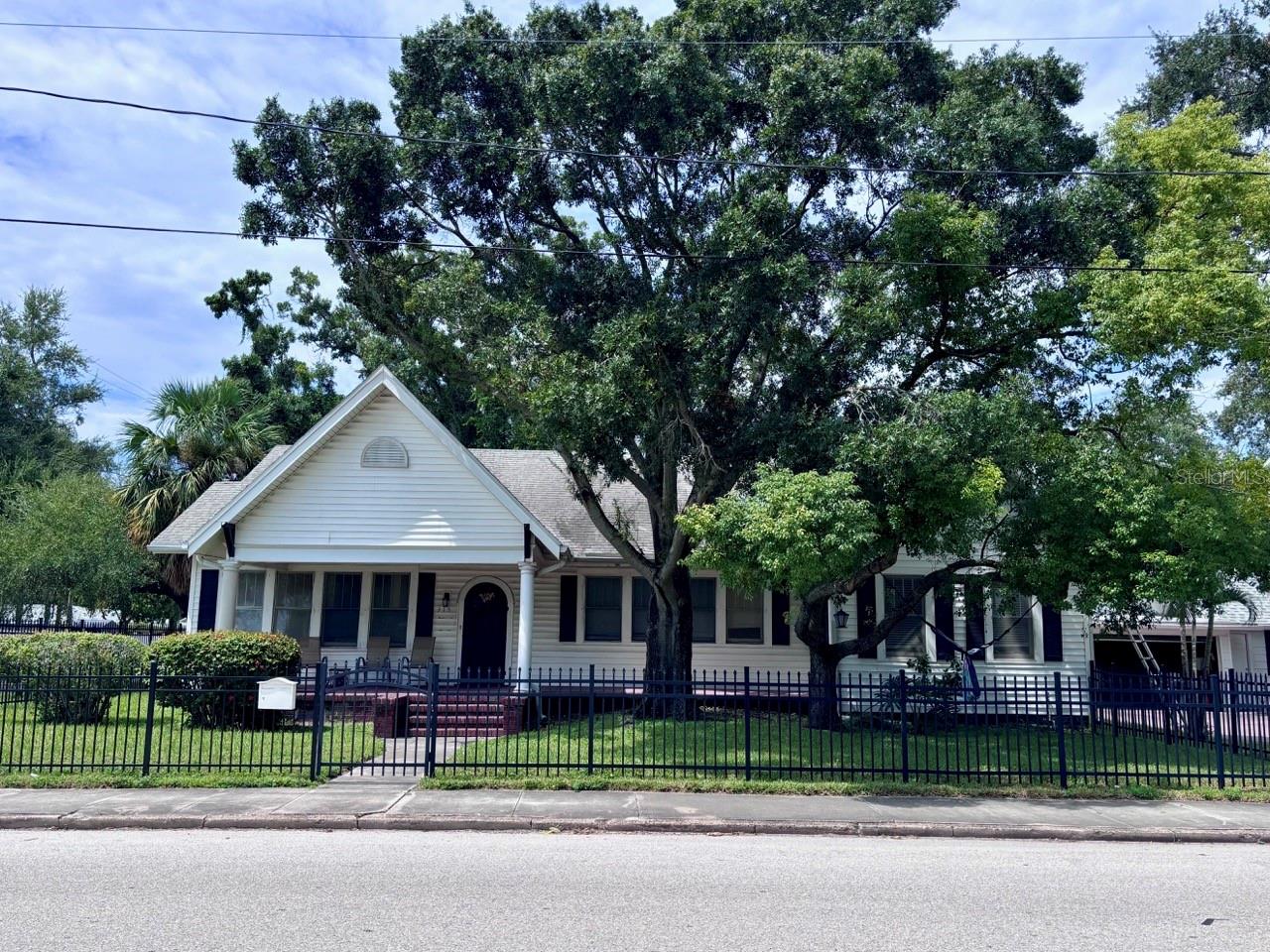 Investment Potential in Palmetto Beach neighborhood, one of Tampa’s historic coastal communities experiencing ongoing revitalization. Perfectly located just 1.5 miles from Historic Ybor City and a mere 2.5 miles from Downtown Tampa. Set elegantly on an oversized 77 by 118 foot corner lot directly across from the sparkling waters of McKay Bay, this 1933 bungalow represents a rare, defining opportunity in the Tampa Bay market. 2,168 square feet of living space with 3 bedrooms and 2 bathrooms is a dramatic architectural canvas waiting for its next chapter, whether that means a grand restoration or the creation of a brand new custom luxury estate.

The home features 12-foot ceilings throughout, and sunlight pours through several large windows in each room. True craftsmanship echoes through the custom crown moldings, intricate ceiling dials, beautifully framed doors and windows, and graceful arched openings that connect the main living areas. A classic wood burning fireplace stands ready to serve as the heart of the home. Functional extras include a partially floored attic for abundant storage and a brand new roof installed in October 2024.

An oversized detached two car garage provides exceptional utility, complete with a laundry room, storage room, and plumbing already in place for a half bathroom. The detached layout and generous lot size could offer potential for the future construction of a secondary living structure on site. 

The natural beauty of the McKay Bay bird estuary and the sprawling amenities of Desoto Park are right across from this property. Residents will enjoy immediate access to a waterfront playground, basketball courts, a soccer field, a skate park, walking and jogging trails, and a beautiful zero entry public pool.

Location is everything, and this property sits at the epicenter of Tampa's most exciting multi-million dollar transformations. Just a little over a mile away, the 50 acre Gas Worx mixed use development will seamlessly connect Ybor to Downtown, while the Ybor Harbor project will introduce a vibrant waterfront boardwalk, premier dining, and lush green spaces. Even closer, the neighborhood is poised for an evolution. The City of Tampa’s Pathways to Palmetto Project is proposed to reconstruct the McKay Bay seawall, add modern sidewalks, and revitalize Bermuda Boulevard. The northern lot next door will have a new build, similar to the 2023 new build next to it, in 2026/2027. 

Please note, this property has experienced previous flooding and fire damage. It is being sold strictly as-is, presented as a full remodel opportunity or a premier tear-down site for an exquisite new construction build. Whether you are a local custom builder looking for your next marquee project, a seasoned investor ready for a major flip, or an ambitious primary buyer wanting to build a forever home with views of the water, bring your contractor and your imagination to claim your piece of the Tampa waterfront lifestyle.