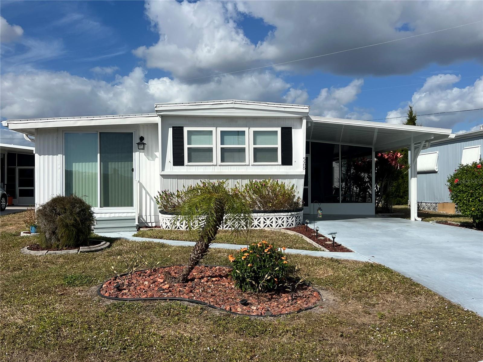 JUST REDUCED by $10K! This is currently the most affordable home in this 55+ WATERFRONT COMMUNITY with Gulf-access via the Myakka River. This well-maintained home offers incredible value with low HOA fees of just $175 PER MONTH with no additional lot rent. The layout lives larger than expected — a singlewide enhanced by a fully finished 280 sq ft addition for a total of 844 sq ft of comfortable, easy-care living space. The super clean interior has an open floor plan, attractive laminate flooring, and includes most furnishings needed for a quick move-in. The kitchen was updated this year with a new stove, cooktop, built-in oven and microwave, and an island perfect for prepping and serving. The living room and dining room share one large open space great for hosting get-togethers with friends and family. There is a split bedroom plan for privacy and the 2nd bedroom has its own entrance so guests can come and go as they please. The primary bedroom is spacious with a king size bed, 3 separate closets and built in storage drawers. The bathroom is just around the corner with large vanity and updated walk in shower. Plan to spend a lot of time in the private screened lanai enjoying morning beverages and evening breezes. Big ticket updates are completed including a new roof, carport, and lanai (2025), a vapor barrier and windows replaced approximately five years ago, and an AC system of similar age with consistent maintenance. Located in Harbor Cove, residents enjoy fantastic amenities. The large clubhouse overlooks the 90-SLIP MARINA plus two swimming pools, a hot tub, bocce, shuffleboard, tennis and pickleball courts, a fitness center, library, craft rooms, and a woodworking shop. A full calendar of dances, picnics, parties, entertainment, and games ensures there is always something fun to do — a perfect winter escape. Boating and fishing opportunities are practically at your doorstep, with boat slips available for just $300 per year. And when you’re ready to explore on land, you’re minutes from Gulf beaches, dining, shopping, golf, spring training baseball, and more. A wonderful opportunity to enjoy a warm, relaxed lifestyle in a welcoming community. Schedule your private tour today!