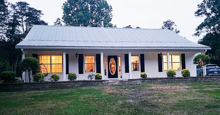 PRIDE OF OWNERSHIP! Welcome to your private slice of paradise, where country living meets modern comfort on 5 peaceful picturesque acres surrounded by the sounds of nature. 
  Drive up along a picturesque lane lined with beautiful oak trees and enter through a custom wrought iron gate onto this stunning property. An inviting introduction to the peaceful retreat that awaits. This exceptional 2002, 3-bedroom, 2 bath custom home, built with steel beam framing inside and out, is surrounded by mature landscaping, shrubbery, and fruit trees. You won't miss the magnificent live oak trees, including one over 100 years old that has served as a stunning backdrop for countless wedding photos.
  Inside, the home offers over 2,267 square feet of thoughtfully designed living space, featuring luxury vinyl plank flooring with a vapor barrier throughout and 10-foot ceilings. The spacious master suite includes a walk-in closet and completely remodeled bathroom with a custom tiled shower, elegant quartz countertops, modern sink, and new vanity. Two additional guest bedrooms share a well-appointed complete bathroom. This home offers ample lighting, windows, and coverings, with plenty of storage throughout.
  For the cooks in the family, you won't want to miss this completely upgraded gorgeous kitchen, dining area showcasing hardwood oak soft-close cabinetry, newer appliances, with an eating bar adorned with granite countertops perfect for everyday living and entertaining. 
  The cozy living area is highlighted by a freestanding wood-burning stove and a gorgeous floor-to-ceiling stone accent wall. Enjoy the 36' x 8' sunroom with a split unit just off the kitchen, where you can sit and relax with your morning coffee.
  Step outside and enjoy an outdoor kitchen and fire pit, including accent patio lighting, complete with a gas grill and fryer, ideal for hosting gatherings. The property is fully fenced and cross-fenced, currently home to geese, goats, and exotic chickens housed in a custom-built coop. You will notice as you drive onto the property, there is a free-standing shelter 31'x20' to store your farm equipment.
  Equestrian enthusiasts will appreciate the barn, including two 12' x 12' stalls and a 24' tack room, complete with a water supply, with a 12'
 wide breezeway that includes power and is well-lit. This property also has a 12'x20'' shed behind the home for more storage. You will have to see the many additional highlights added to this amazing property to appreciate the owners love of this homesite.
  Additional highlights include:
Interior paint 2021-Exterior paint 2024-Irrigation system throughout the property-Whole-house hardwired generator-Metal roof with new screws (2023)-HVAC system (approx. 5 years old)-Well and septic replaced in 2026-Owned 55-gallon Marathon gas tank
Water Purification system newly serviced-Updated appliances including Bosch dishwasher (2024), microwave (2024), stove (2014), and refrigerator (2014)-Exterior paint (2024) -Insulation with 6” R-factor and R-30 exterior walls.
  This meticulously maintained property reflects true pride of ownership and offers a peaceful retreat where you can unwind and enjoy the sounds of nature. You will have to see it to appreciate all the beauty this homesite offers.
  Conveniently located near shopping, dining, schools, medical facilities, U OF F, and the I-75 corridor—with world-renowned freshwater springs just a short drive away.
Schedule your private showing today!