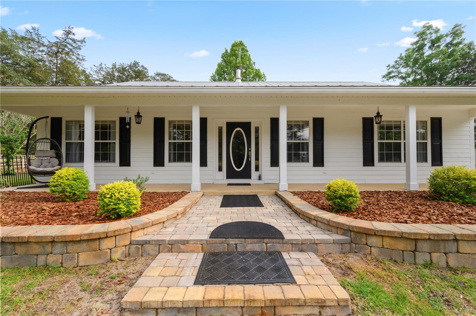 PRIDE OF OWNERSHIP! Welcome to your private slice of paradise, where country living meets modern comfort on 5 peaceful picturesque acres surrounded by the sounds of nature. 
  Drive up along a picturesque lane lined with beautiful oak trees and enter through a custom wrought iron gate onto this stunning property. An inviting introduction to the peaceful retreat that awaits. This exceptional 2002, 3-bedroom, 2 bath custom home, built with steel beam framing inside and out, is surrounded by mature landscaping, shrubbery, and fruit trees. You won't miss the magnificent live oak trees, including one over 100 years old that has served as a stunning backdrop for countless wedding photos.
  Inside, the home offers over 2,267 square feet of thoughtfully designed living space, featuring luxury vinyl plank flooring with a vapor barrier throughout and 10-foot ceilings. The spacious master suite includes a walk-in closet and completely remodeled bathroom with a custom tiled shower, elegant quartz countertops, modern sink, and new vanity. Two additional guest bedrooms share a well-appointed complete bathroom. This home offers ample lighting, windows, and coverings, with plenty of storage throughout.
  For the cooks in the family, you won't want to miss this completely upgraded gorgeous kitchen, dining area showcasing hardwood oak soft-close cabinetry, newer appliances, with an eating bar adorned with granite countertops perfect for everyday living and entertaining. 
  The cozy living area is highlighted by a freestanding wood-burning stove and a gorgeous floor-to-ceiling stone accent wall. Enjoy the 36' x 8' sunroom with a split unit just off the kitchen, where you can sit and relax with your morning coffee.
  Step outside and enjoy an outdoor kitchen and fire pit, including accent patio lighting, complete with a gas grill and fryer, ideal for hosting gatherings. The property is fully fenced and cross-fenced, currently home to geese, goats, and exotic chickens housed in a custom-built coop. You will notice as you drive onto the property, there is a free-standing shelter 31'x20' to store your farm equipment.
  Equestrian enthusiasts will appreciate the barn, including two 12' x 12' stalls and a 24' tack room, complete with a water supply, with a 12'
 wide breezeway that includes power and is well-lit. This property also has a 12'x20'' shed behind the home for more storage. You will have to see the many additional highlights added to this amazing property to appreciate the owners love of this homesite.
  Additional highlights include:
Interior paint 2021-Exterior paint 2024-Irrigation system throughout the property-Whole-house hardwired generator-Metal roof with new screws (2023)-HVAC system (approx. 5 years old)-Well and septic replaced in 2026-Owned 55-gallon Marathon gas tank
Water Purification system newly serviced-Updated appliances including Bosch dishwasher (2024), microwave (2024), stove (2014), and refrigerator (2014)-Exterior paint (2024) -Insulation with 6” R-factor and R-30 exterior walls.
  This meticulously maintained property reflects true pride of ownership and offers a peaceful retreat where you can unwind and enjoy the sounds of nature. You will have to see it to appreciate all the beauty this homesite offers.
  Conveniently located near shopping, dining, schools, medical facilities, U OF F, and the I-75 corridor—with world-renowned freshwater springs just a short drive away.
Schedule your private showing today!