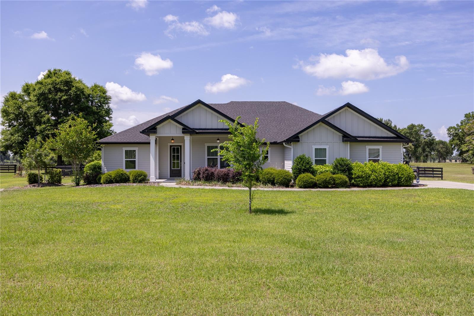 Calling all horse lovers! Experience luxury living and peaceful North Florida charm in this exceptional 4-bedroom, 3-bath custom home situated on a beautifully landscaped 1-acre lot in the highly sought-after equestrian community of The Oaks in Lake City. Built with quality craftsmanship and loaded with upgrades, this stunning residence offers the perfect blend of elegance, comfort, and functionality. From the moment you enter the inviting foyer, you are welcomed into a spacious great room featuring a tray ceiling, expansive windows, and an abundance of natural light that creates a warm and inviting atmosphere.

The open-concept kitchen is designed to impress with a large quartz-topped island, subway tile backsplash, smooth-top range and oven, spacious breakfast nook, oversized dining area, custom walk-in pantry, and abundant cabinetry ideal for both entertaining and everyday living. The thoughtfully designed split floor plan offers privacy and flexibility, including a tucked-away fourth bedroom perfect for guests, a home office, den, or flex space. Hidden barn doors connecting two bedrooms and a bathroom, add charm and character to the home’s design.

The luxurious owner’s suite serves as a true retreat with a spa-inspired bathroom featuring dual vanities, a standalone soaking tub, oversized walk-in tiled shower, and a custom California-style walk-in closet complete with built-in shelving and laundry hamper. Additional interior features include remote-controlled ceiling fans throughout, a spacious laundry room with utility sink and large storage closet, pull-down attic access, AT&T Fiber internet, Culligan water system, hot water recirculation pump, and a whole-house Generac generator for added convenience and peace of mind.

Step outside into your private backyard oasis featuring a screened covered porch with paver flooring, heated saltwater pool and spa, app-controlled pool system, paver walkways, and a fully fenced backyard with durable horse board fencing. Enjoy the beauty and serenity of nature with riding trails located directly behind the property.

The Oaks is a premier equestrian-friendly community offering riding trails throughout the neighborhood along with community stables and boarding facilities conveniently located within the community. Residents also enjoy scenic green spaces, riding arenas, dressage areas, round pens, and exceptional equestrian amenities designed for a variety of riding disciplines. Conveniently located near shopping, dining, medical facilities, and major roadways, this remarkable property offers luxury, privacy, and an exceptional lifestyle all in one extraordinary package.