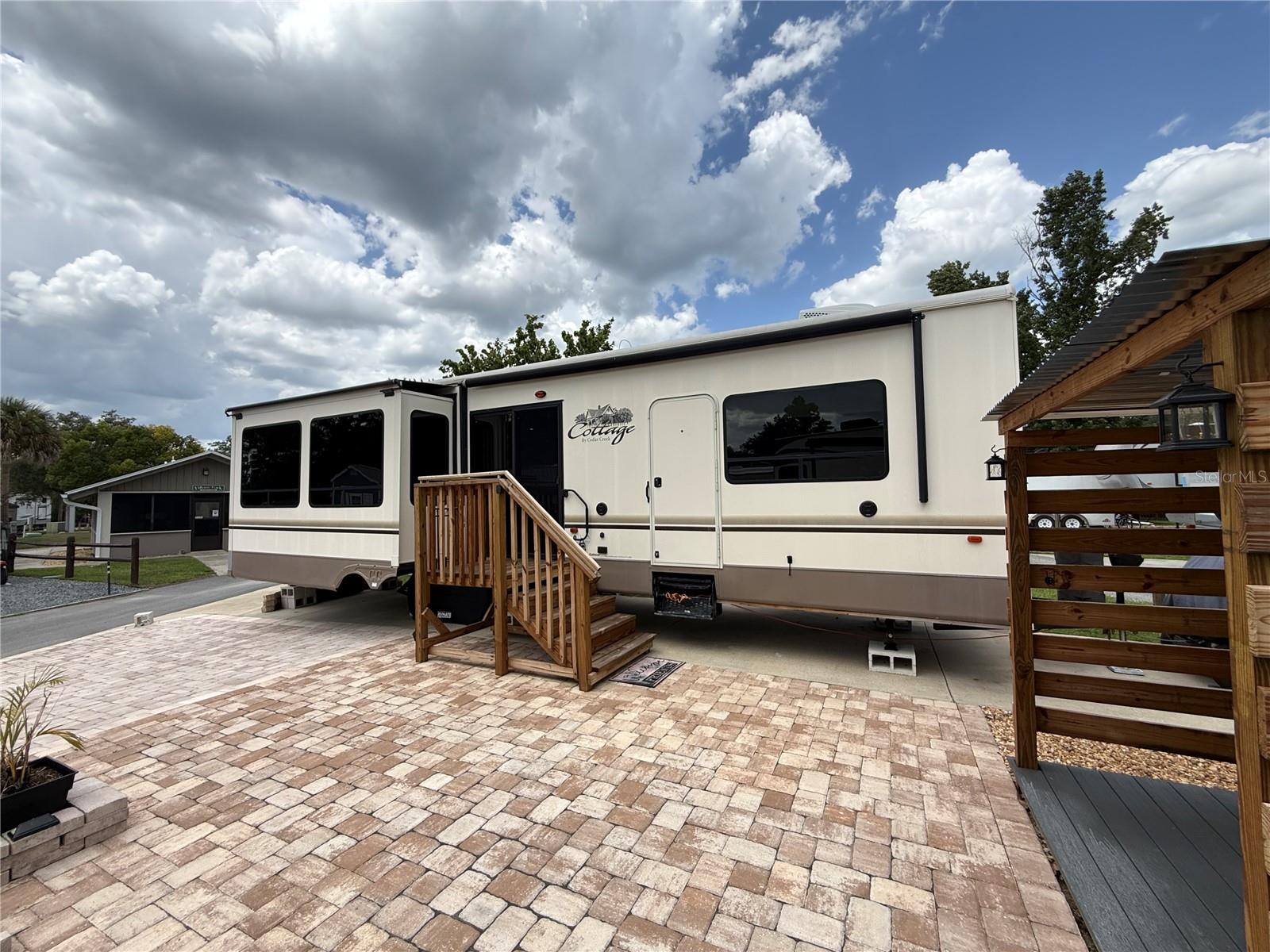 Welcome to your own private getaway in the highly sought-after Wilderness RV Resort, one of Central Florida's premier deeded RV communities where resort living, nature and adventure come together. This beautifully improved property is being offered as a complete package and includes a well-maintained 2016 Cedar Creek Cottage 40CRS, allowing you to move right in and begin enjoying the Florida lifestyle. The cottage features soaring 8-foot ceilings that create an open, spacious feel, a recently replaced living room air conditioner approximately six months ago for added comfort, and a professionally sealed roof completed less than a year ago, providing additional peace of mind. Outside, the lot is beautifully finished with extensive paver hardscaping, creating an inviting outdoor living space complete with a charming gazebo that is perfect for relaxing with your morning coffee or unwinding after a day of exploring the surrounding natural beauty. One of the most unique advantages of this property is its exceptional location directly across from the community's screened pavilion. Whether you're hosting family gatherings, entertaining friends, or simply need additional space during holidays or special occasions, the pavilion offers a wonderful extension of your outdoor living area and even includes a convenient half bath for guests. Wilderness RV Resort is a gated waterfront community offering an impressive collection of amenities including a swimming pool, hot tub, clubhouse, fitness center with both free weights and exercise equipment, sauna, steam room, recreation room, laundry facilities, and an extra-large dog park where your four-legged family members can run and play. Nature lovers will appreciate the scenic golf cart trails leading along the beautiful Ocklawaha River, where wildlife sightings often include deer, turtles, countless bird species, and if you're lucky, even the famous wild monkeys that inhabit the nearby Silver Springs area. Bring your kayak and experience one of Florida's most unforgettable adventures by launching at Silver Springs State Park and paddling downstream directly to Wilderness RV Resort. Just outside the entrance you'll find a local favorite serving breakfast and lunch along with the famous MoonPie General Store, while only a short drive west on Highway 40 brings you to the heart of historic downtown Ocala. Spend the evening enjoying fine dining at Mark's Prime Steakhouse, Harry's Seafood Bar & Grille, Brick City Southern Kitchen, Ivy on the Square, or catch a show at the beautifully restored Marion Theatre before strolling around one of Florida's most vibrant historic downtown districts. Everyday conveniences including Walmart, shopping, medical facilities and additional restaurants are approximately ten minutes away, making this the perfect combination of peaceful resort living and modern convenience. Whether you're searching for a seasonal retreat, a winter escape or a full-time Florida lifestyle, this turnkey package is ready for you to begin making memories from day one.